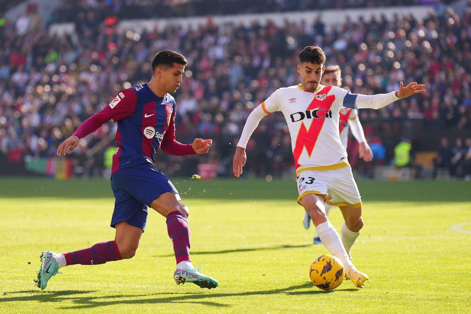 MADRID, SPAIN - NOVEMBER 25: Joao Cancelo of FC Barcelona and Oscar Valentin of Rayo Vallecano battle for possession during the LaLiga EA Sports match between Rayo Vallecano and FC Barcelona at Estadio de Vallecas on November 25, 2023 in Madrid, Spain.