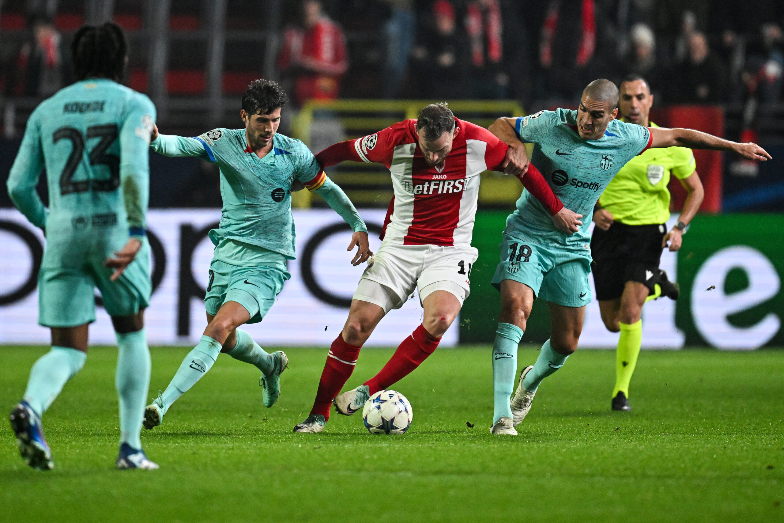Antwerp's Dutch forward #18 Vincent Janssen (C) fights for the ball with Barcelona's Spanish midfielder #20 Sergi Roberto (L) and Barcelona's Spanish midfielder #18 Oriol Romeu (R) during the UEFA Champions League Group H football match between Royal Antwerp FC and FC Barcelona at the Bosuilstadion in Antwerp, on December 13, 2023.
