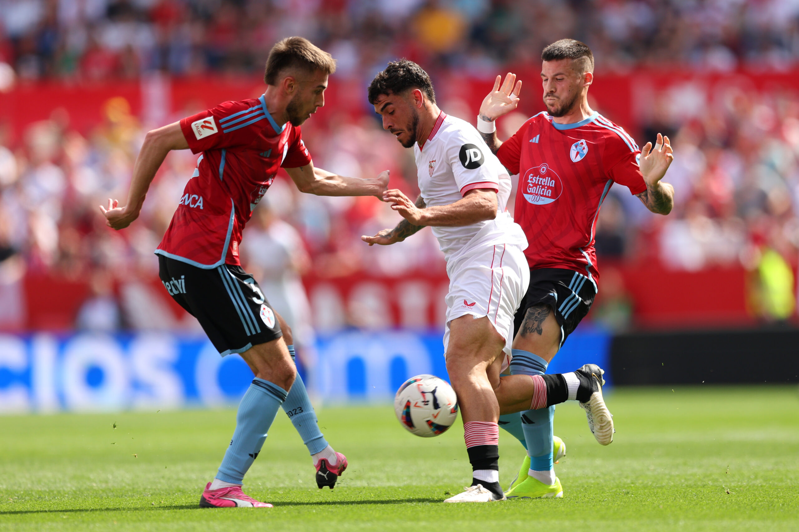 SEVILLE, SPAIN - MARCH 17: Isaac Romero of Sevilla FC is challenged by Oscar Mingueza of Celta Vigo during the LaLiga EA Sports match between Sevilla FC and Celta Vigo at Estadio Ramon Sanchez Pizjuan on March 17, 2024 in Seville, Spain.