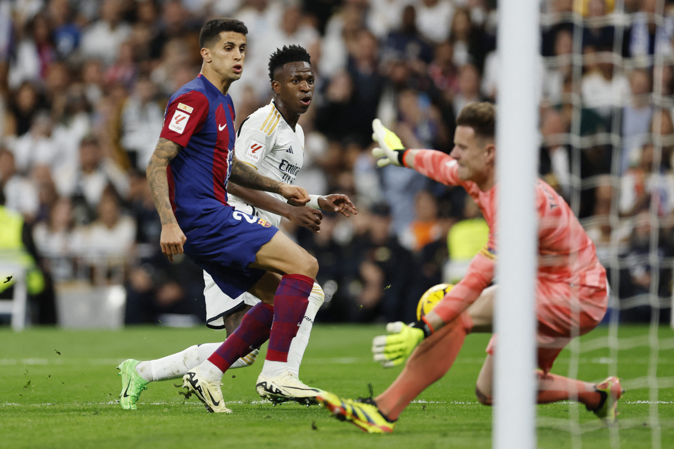Barcelona's Portuguese defender #02 Joao Cancelo (L) challenges Real Madrid's Brazilian forward #07 Vinicius Junior as he attempts to score during the Spanish league football match between Real Madrid CF and FC Barcelona at the Santiago Bernabeu stadium in Madrid on April 21, 2024.
