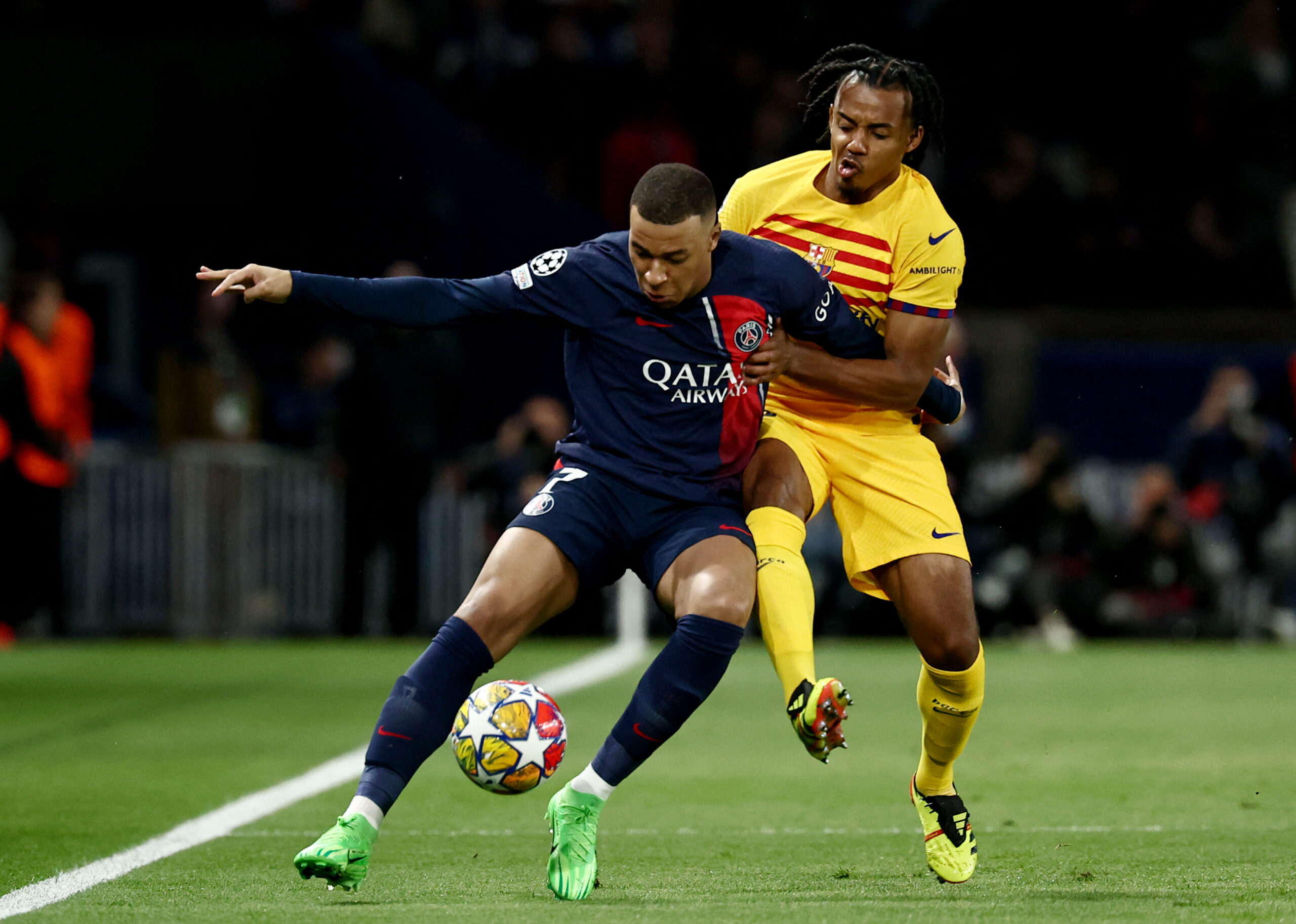 Paris Saint-Germain's French forward #07 Kylian Mbappe (L) and Barcelona's French defender #23 Jules Kounde (R) fight for the ball during the UEFA Champions League quarter final first leg football match between Paris Saint-Germain (PSG) and FC Barcelona at the Parc des Princes stadium in Paris on April 10, 2024.
