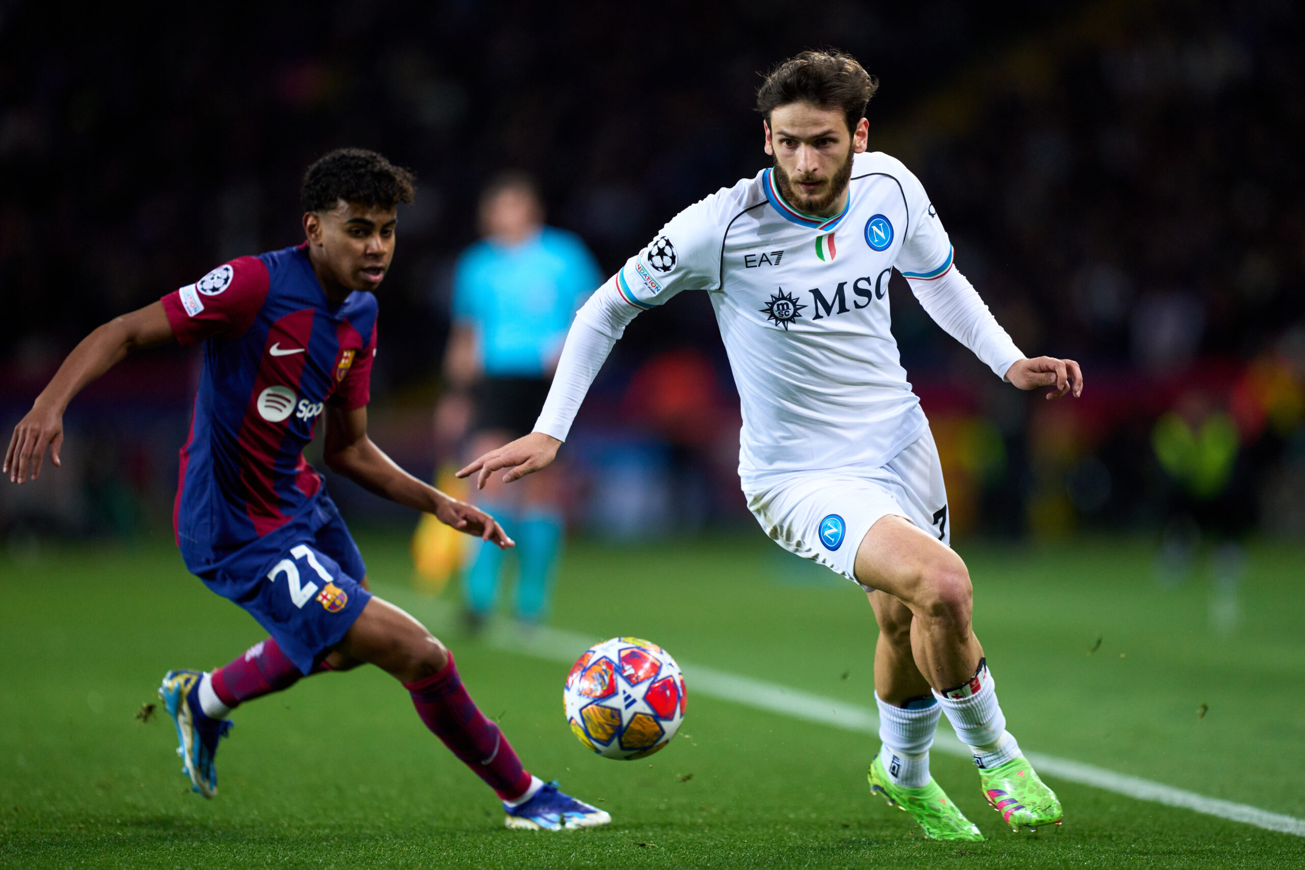 BARCELONA, SPAIN - MARCH 12: Khvicha Kvaratskhelia of SSC Napoli runs with the ball whilst under pressure from Lamine Yamal of FC Barcelona during the UEFA Champions League 2023/24 round of 16 second leg match between FC Barcelona and SSC Napoli at Estadi Olimpic Lluis Companys on March 12, 2024 in Barcelona, Spain.