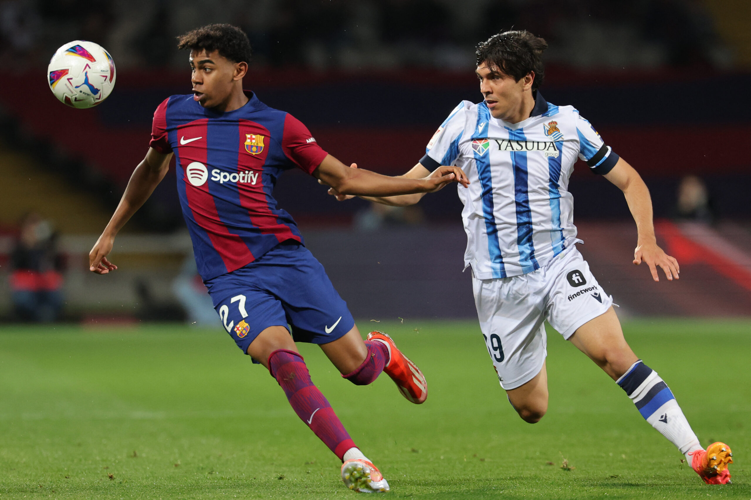 Barcelona's Spanish forward #27 Lamine Yamal vies with Real Sociedad's Venezuelan defender #39 Jon Aramburu during the Spanish league football match between FC Barcelona and Real Sociedad at the Estadi Olimpic Lluis Companys in Barcelona on May 13, 2024.