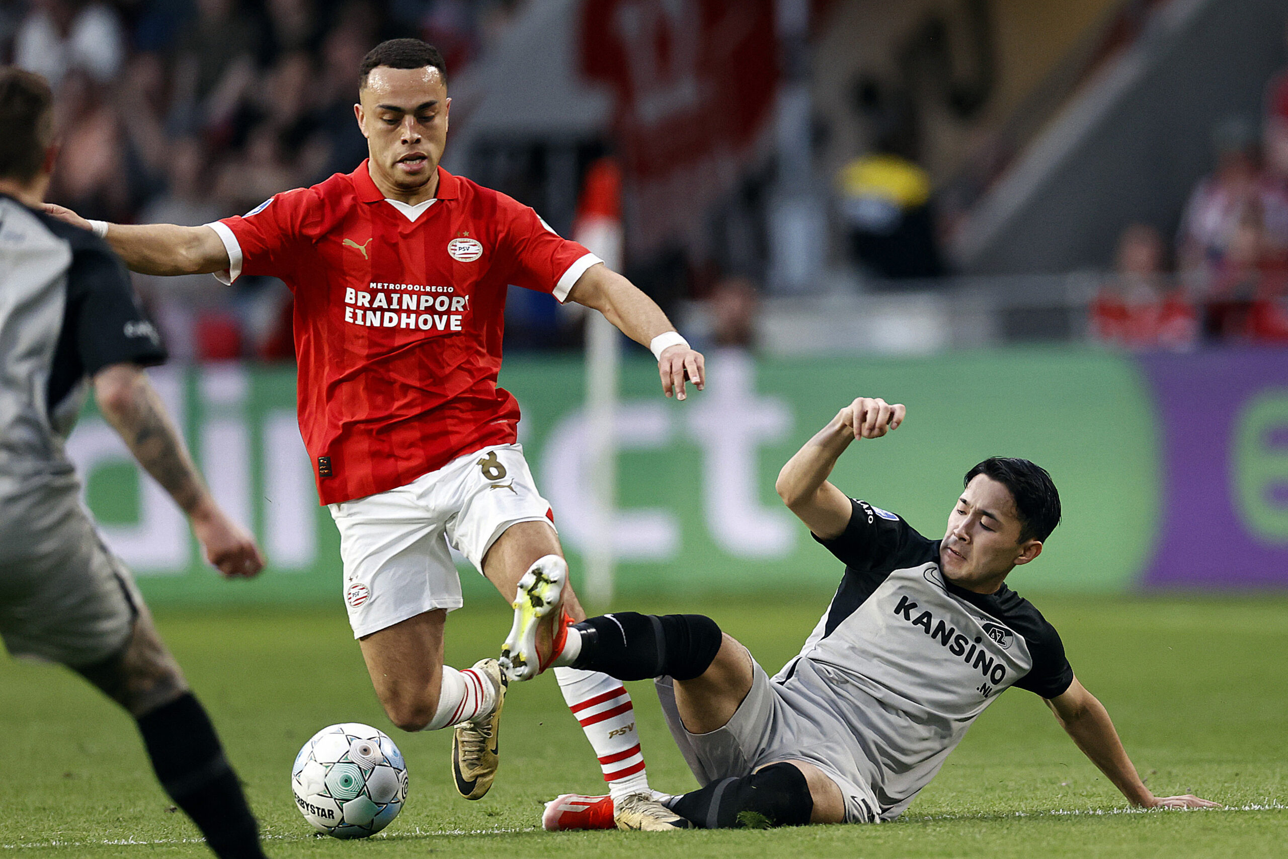 PSV's US defender forward #08 Sergino Dest (L) fights for the ball withAlkmaar's Japanese defender #02 Yukinari Sugawara during the Dutch Eredivisie football match between PSV Eindhoven and AZ Alkmaar at the Philips stadium in Eindhoven, on April 6, 2024.