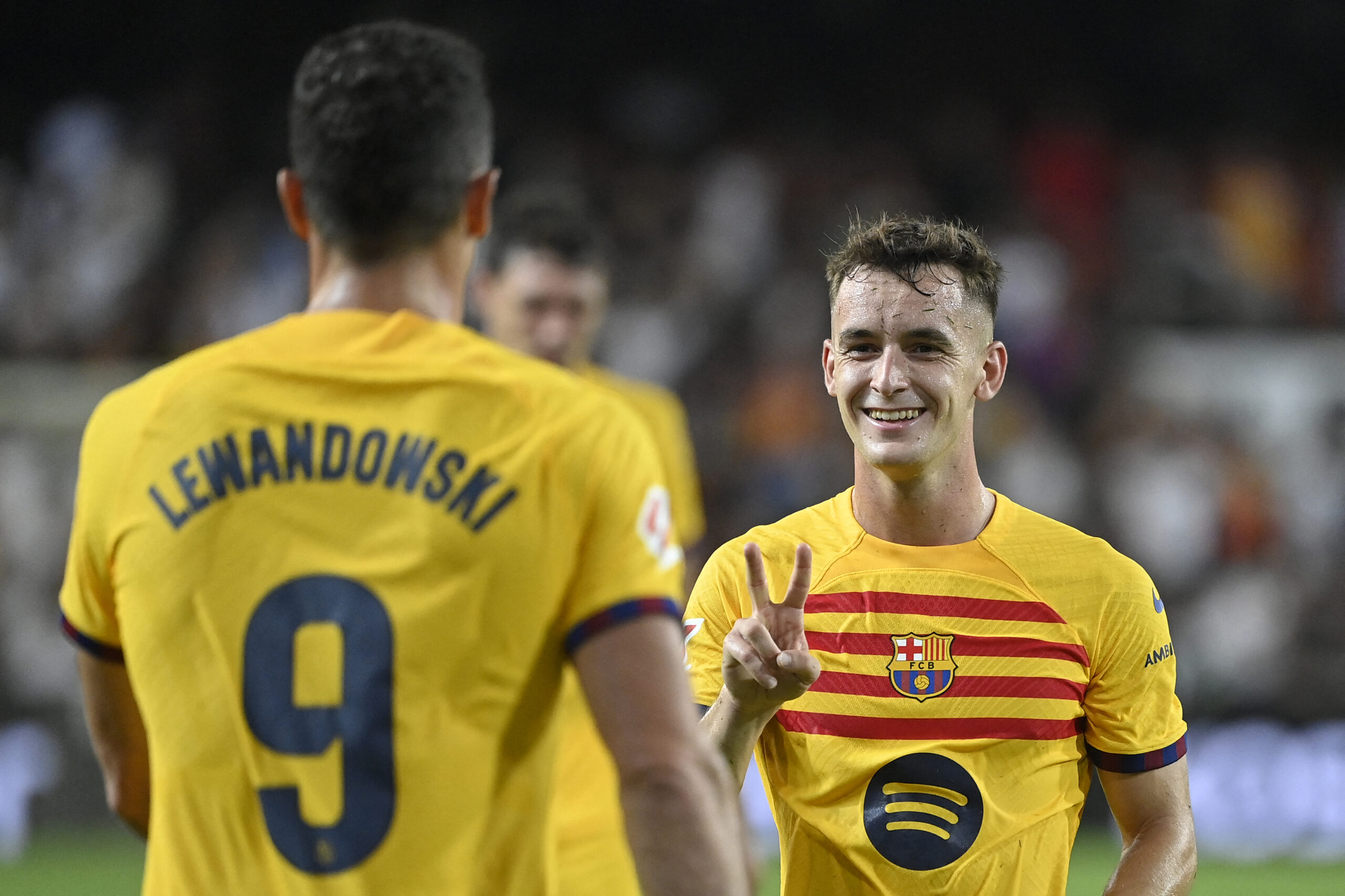 Barcelona's Spanish midfielder #17 Marc Casado (R) celebrates with Barcelona's Polish forward #09 Robert Lewandowski at the end of the Spanish league football match between Valencia CF and Barcelona at the Mestalla stadium in Valencia on August 17, 2024.