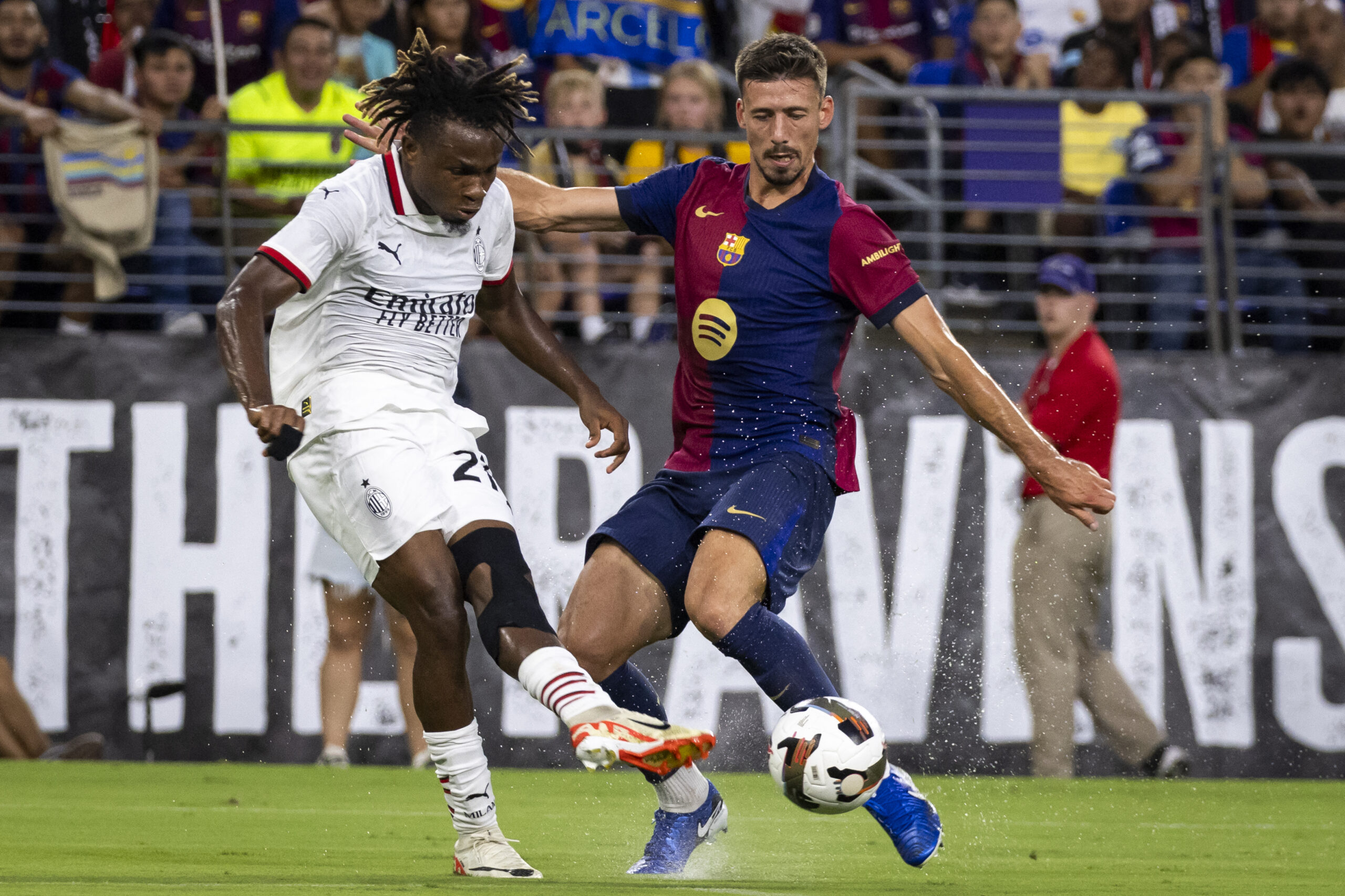 AC Milan's Nigerian midfielder #21 Samuel Chukwueze controls the ball past Barcelona's French defender #04 Clement Lenglet during the pre-season club friendly football match between Barcelona and AC Milan at M&T Bank Stadium in Baltimore, Maryland, August 6, 2024.