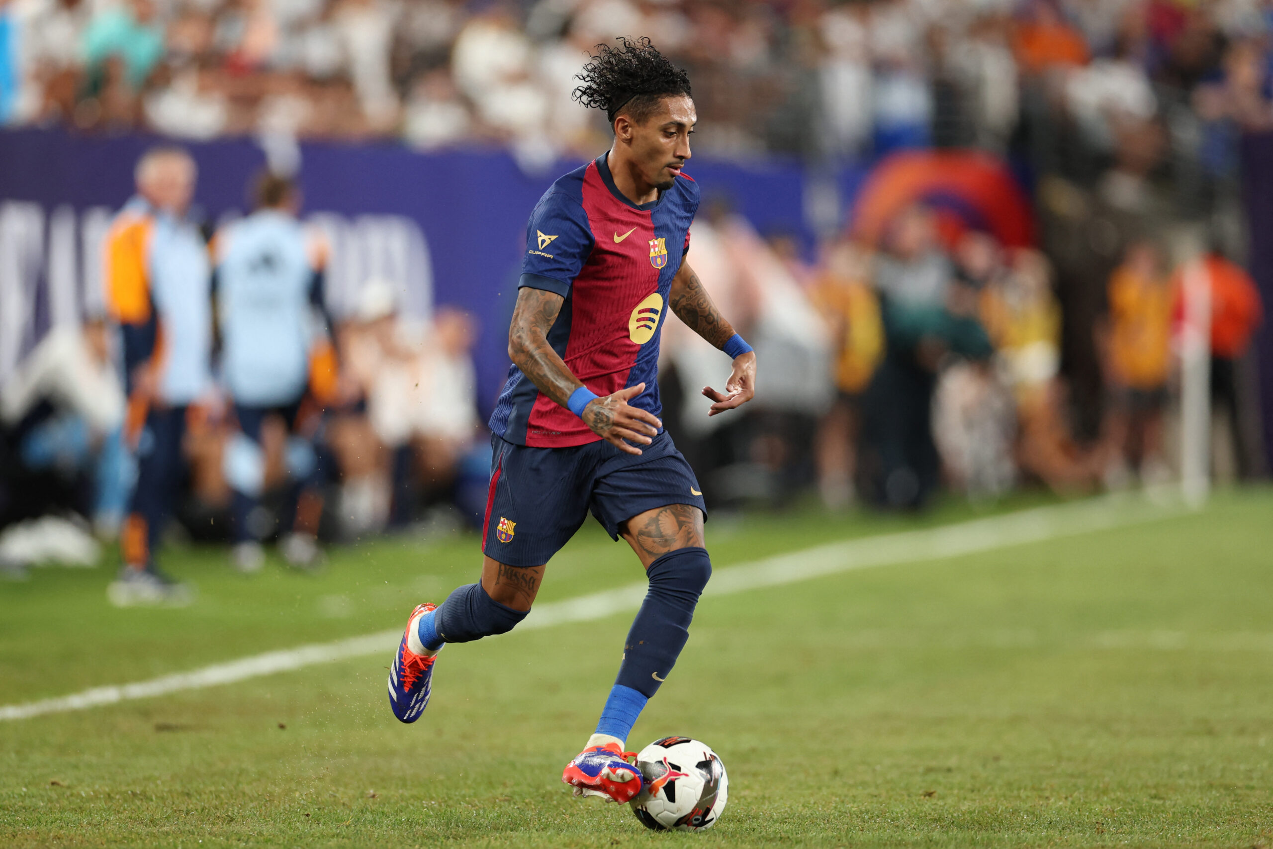 Barcelona's Brazilian forward #11 Raphinha runs with the ball during the pre-season club friendly football match between Real Madrid and Barcelona at MetLife Stadium in East Rutherford, New Jersey, August 3, 2024.