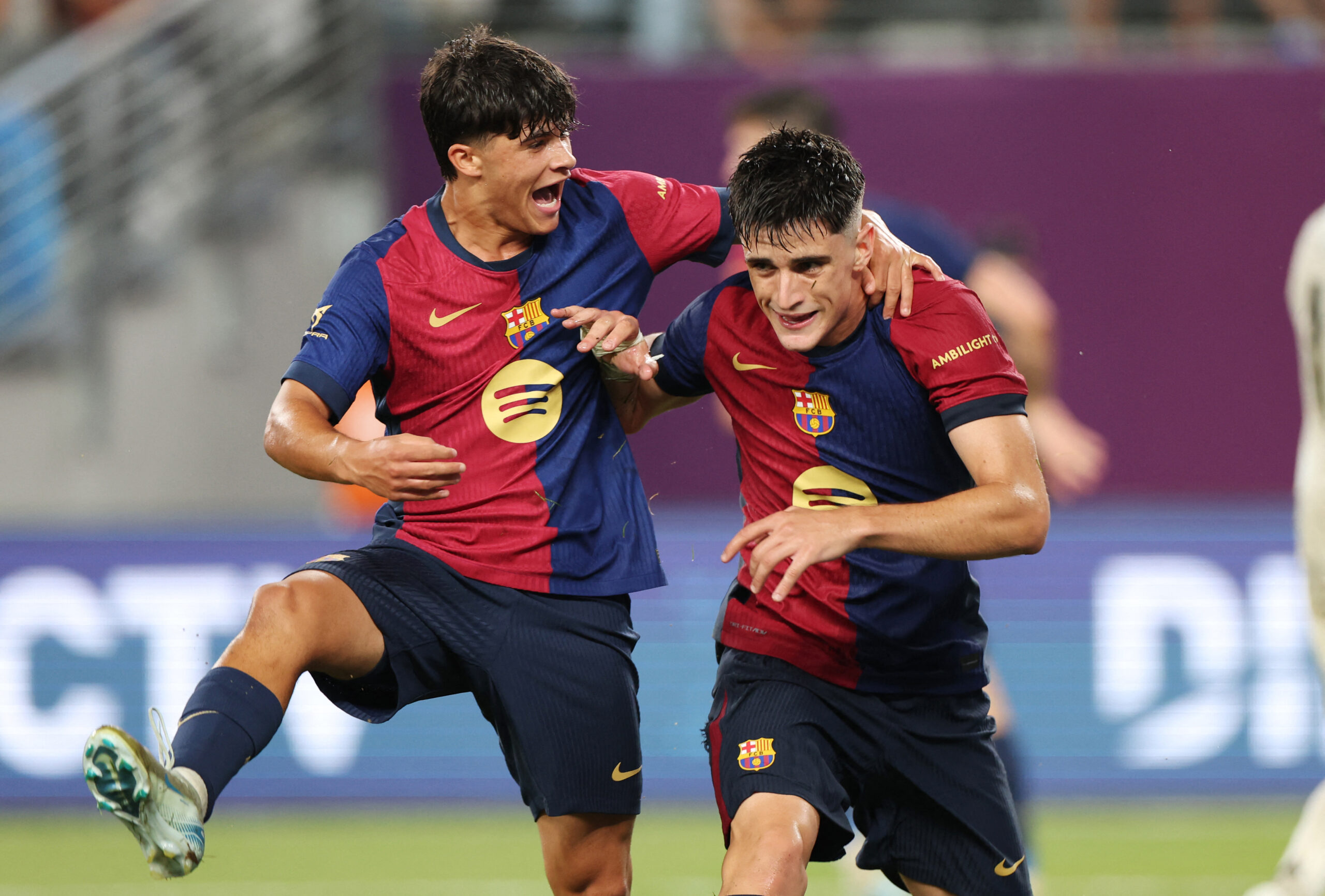 Barcelona's Spanish forward #08 Pau Victor (R) is congratulated by Barcelona's Spanish midfielder #19 Quim Junyent Casanova (L) after scoring a goal during the pre-season club friendly football match between Real Madrid and Barcelona at MetLife Stadium in East Rutherford, New Jersey, August 3, 2024.