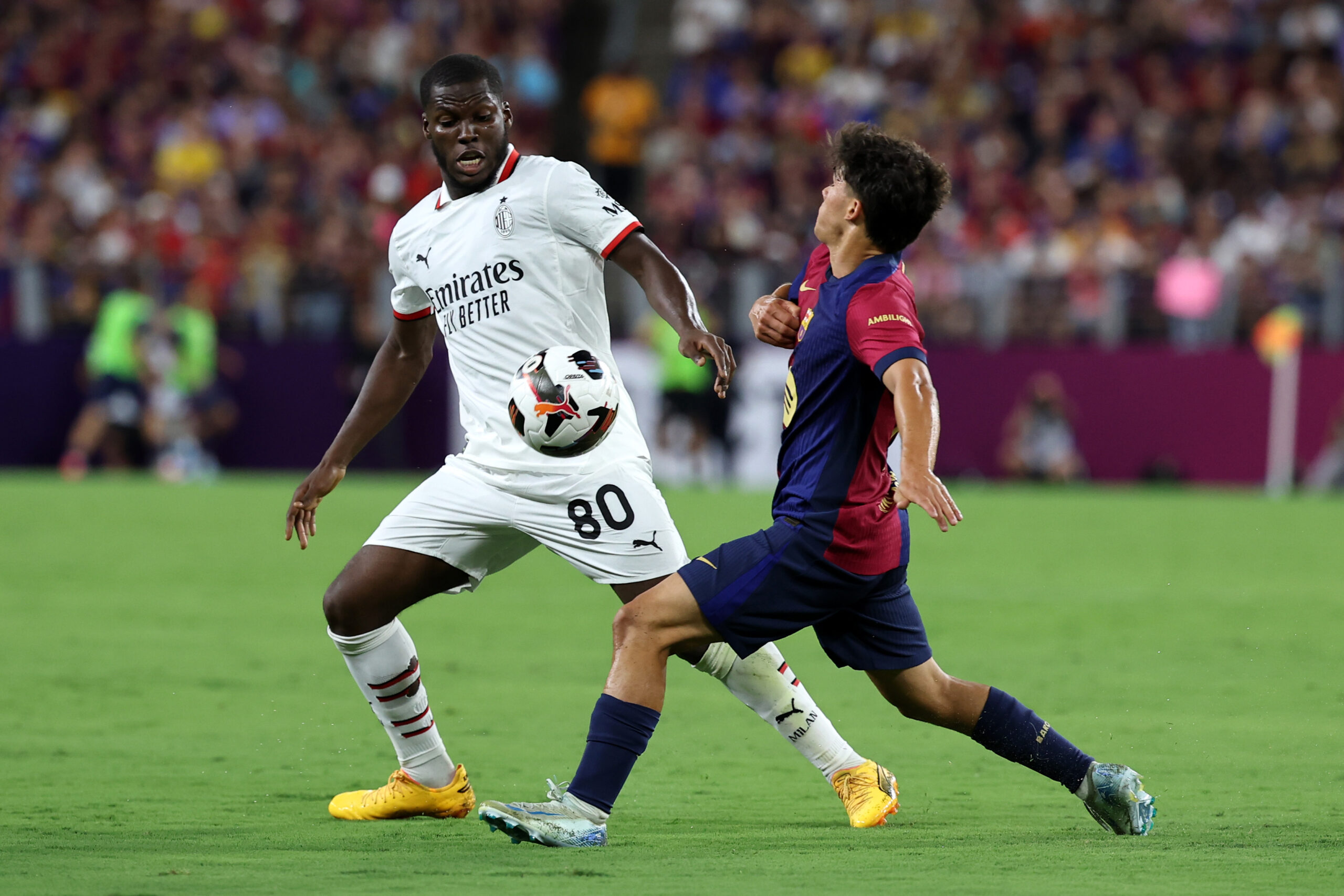 BALTIMORE, MARYLAND - AUGUST 06: Yunus Musah of AC Milan fights for the ball with Marc Bernal of FC Barcelona during a Pre-Season Friendly match between FC Barcelona and AC Milan at M&T Bank Stadium on August 06, 2024 in Baltimore, Maryland.