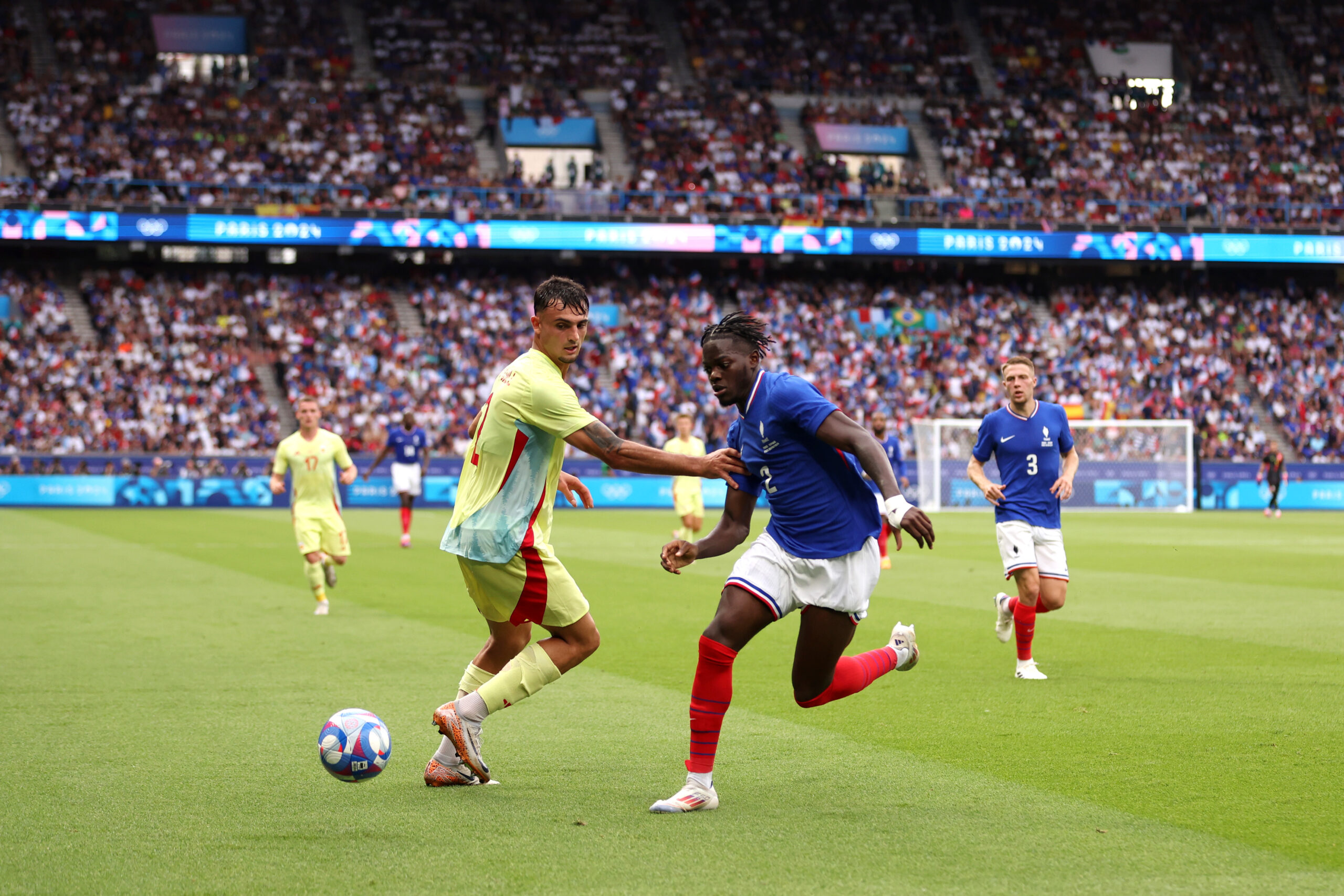 PARIS, FRANCE - AUGUST 09: Castello Lukeba #2 of Team France and Marc Pubill #2 of Team Spain battle for the ball during the Men's Gold Medal match between France and Spain during the Olympic Games Paris 2024 at Parc des Princes on August 09, 2024 in Paris, France.
