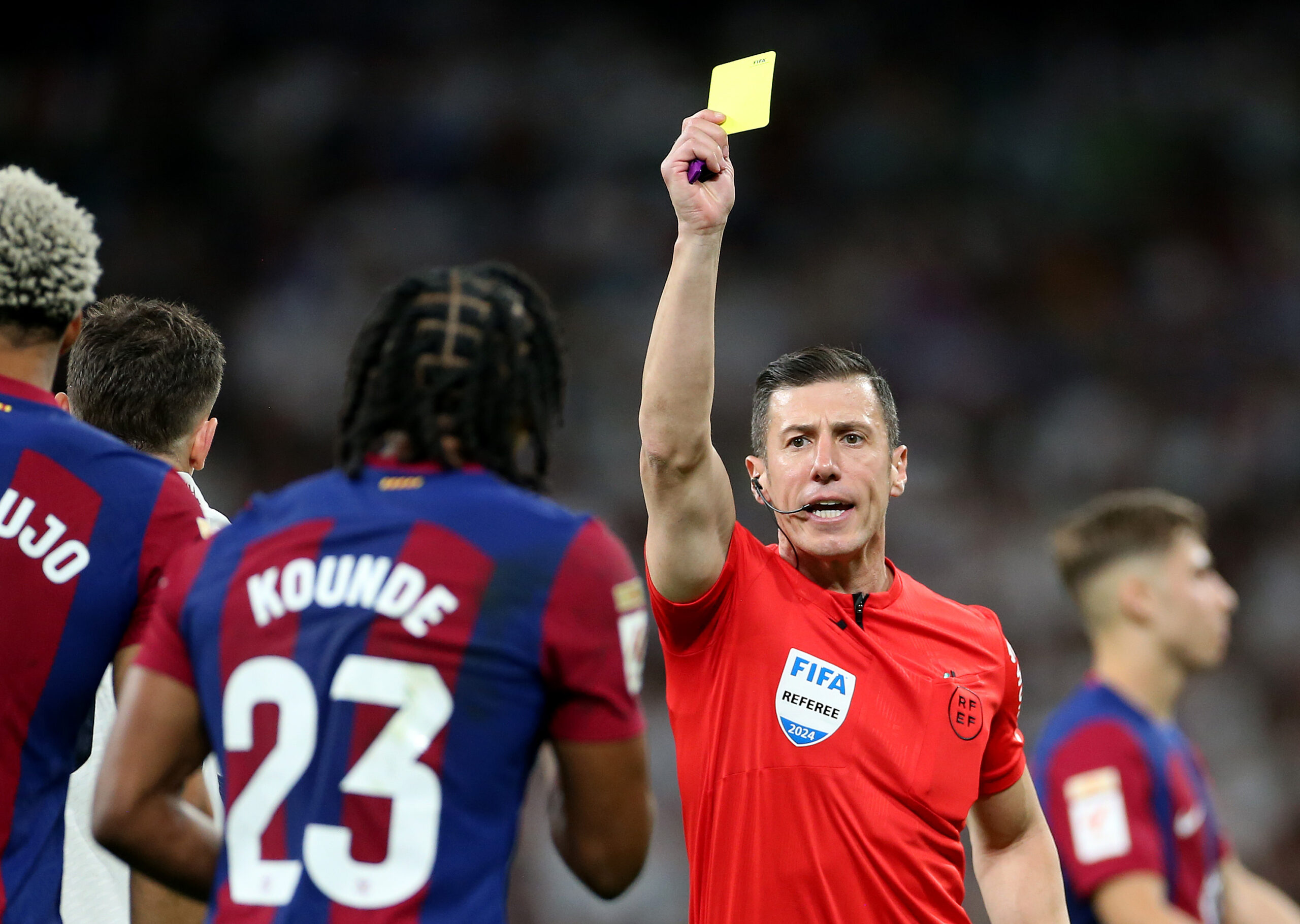 MADRID, SPAIN - APRIL 21: Jules Kounde of FC Barcelona is shown a yellow card by Referee Cesar Soto Grado during the LaLiga EA Sports match between Real Madrid CF and FC Barcelona at Estadio Santiago Bernabeu on April 21, 2024 in Madrid, Spain.