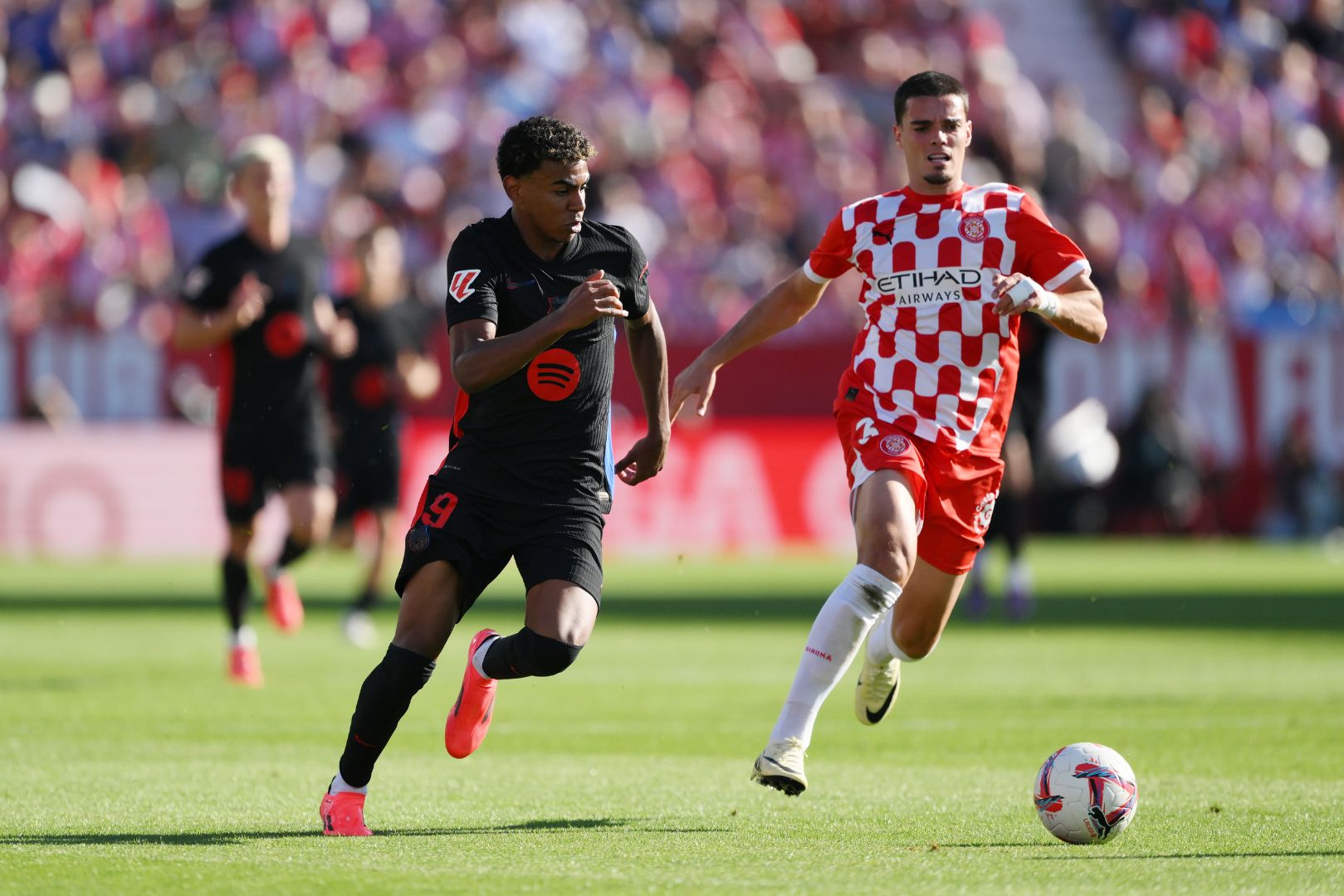 GIRONA, SPAIN - SEPTEMBER 15: Lamine Yamal of FC Barcelona runs with the ball under pressure from Miguel Gutierrez of Girona FC during the LaLiga match between Girona FC and FC Barcelona at Montilivi Stadium on September 15, 2024 in Girona, Spain.