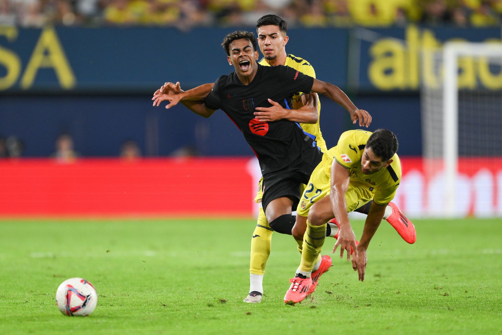 VILLARREAL, SPAIN - SEPTEMBER 22: Lamine Yamal of FC Barcelona is challenged by Ilias Akhomach and Ayoze Perez of Villarreal CF during the LaLiga match between Villarreal CF and FC Barcelona at Estadio de la Ceramica on September 22, 2024 in Villarreal, Spain.