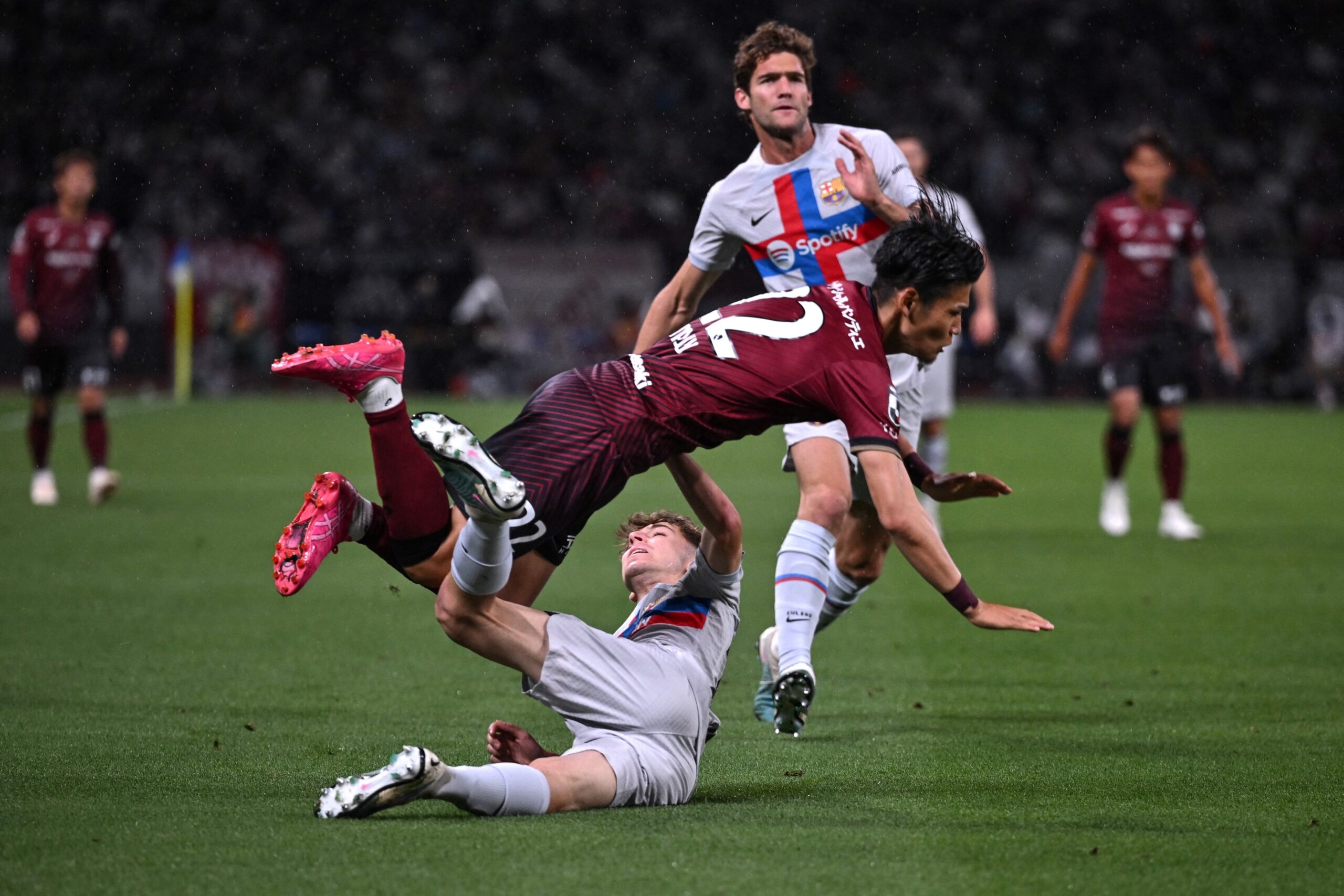 TOPSHOT - Vissel Kobe's Daiju Sasaki (C) clashes with Barcelona's Pau Prim (bottom) and Barcelona's Spanish defender Marcos Alonso (back R) during the football friendly between Japan's Vissel Kobe and Spanish side Barcelona at the Japan National Stadium in Tokyo on June 6, 2023.