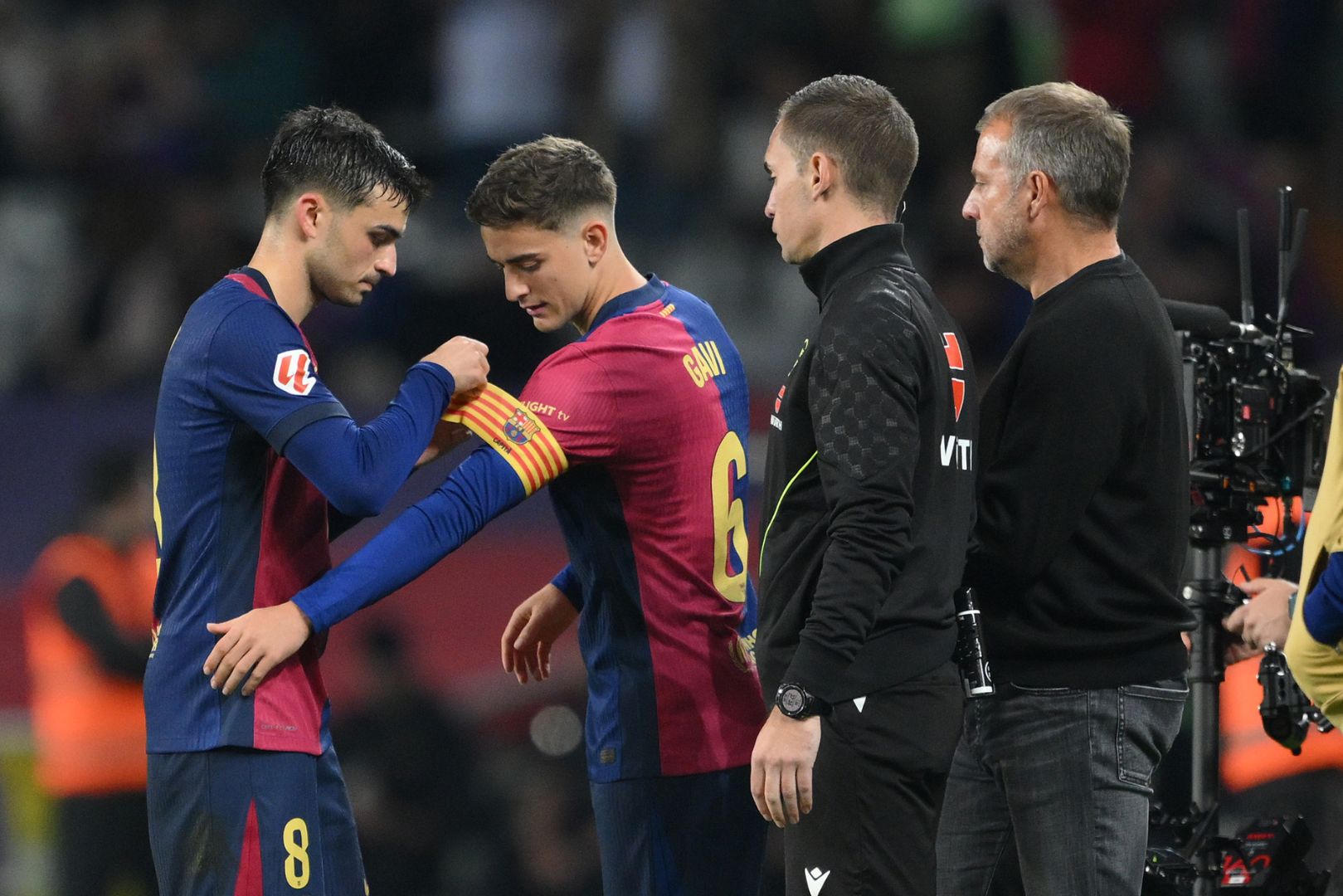 BARCELONA, SPAIN - OCTOBER 20: Pedri of FC Barcelona attaches the captain's armband onto the arm of teammate Gavi whilst being substituted during the La Liga EA Sports match between FC Barcelona and Sevilla FC at Estadi Olimpic Lluis Companys on October 20, 2024 in Barcelona, Spain.