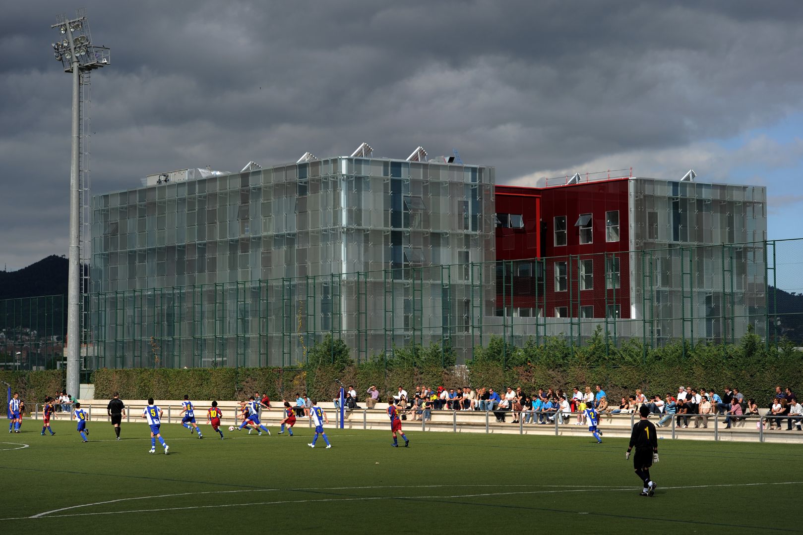 BARCELONA, SPAIN - MAY 15: Youth players of Barcelona and Espanyo play, besides the newly build dormitories for the Barcelona youth players, on one of the pitches at the Joan Camper training ground on May 15, 2011 in Barcelona, Spain. Every weekend various teams of Barcelona youth players play in matches with the hope of one day making it to the top.