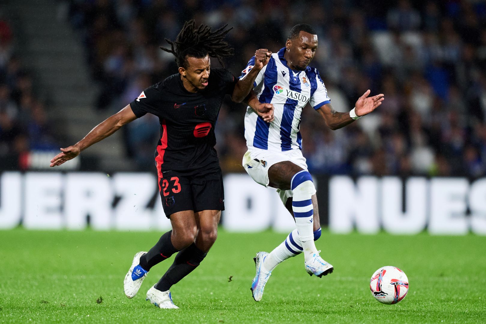 SAN SEBASTIAN, SPAIN - NOVEMBER 10: Sheraldo Becker of Real Sociedad duels for the ball with Jules Kounde of FC Barcelona during the LaLiga match between Real Sociedad and FC Barcelona at Reale Arena on November 10, 2024 in San Sebastian, Spain.