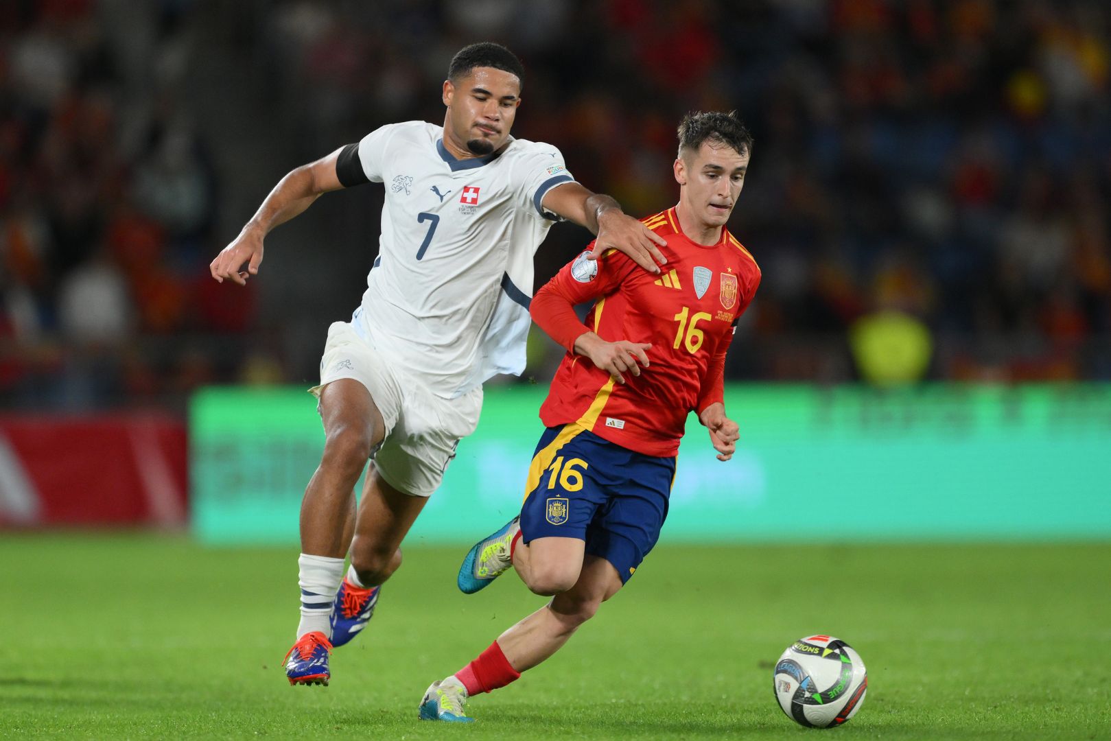 SANTA CRUZ DE TENERIFE, SPAIN - NOVEMBER 18: Marc Casado of Spain is challenged by Simon Sohm of Switzerland during the UEFA Nations League 2024/25 League A Group A4 match between Spain and Switzerland at El Heliodoro Rodriguez Lopez stadium on November 18, 2024 in Santa Cruz de Tenerife, Spain.