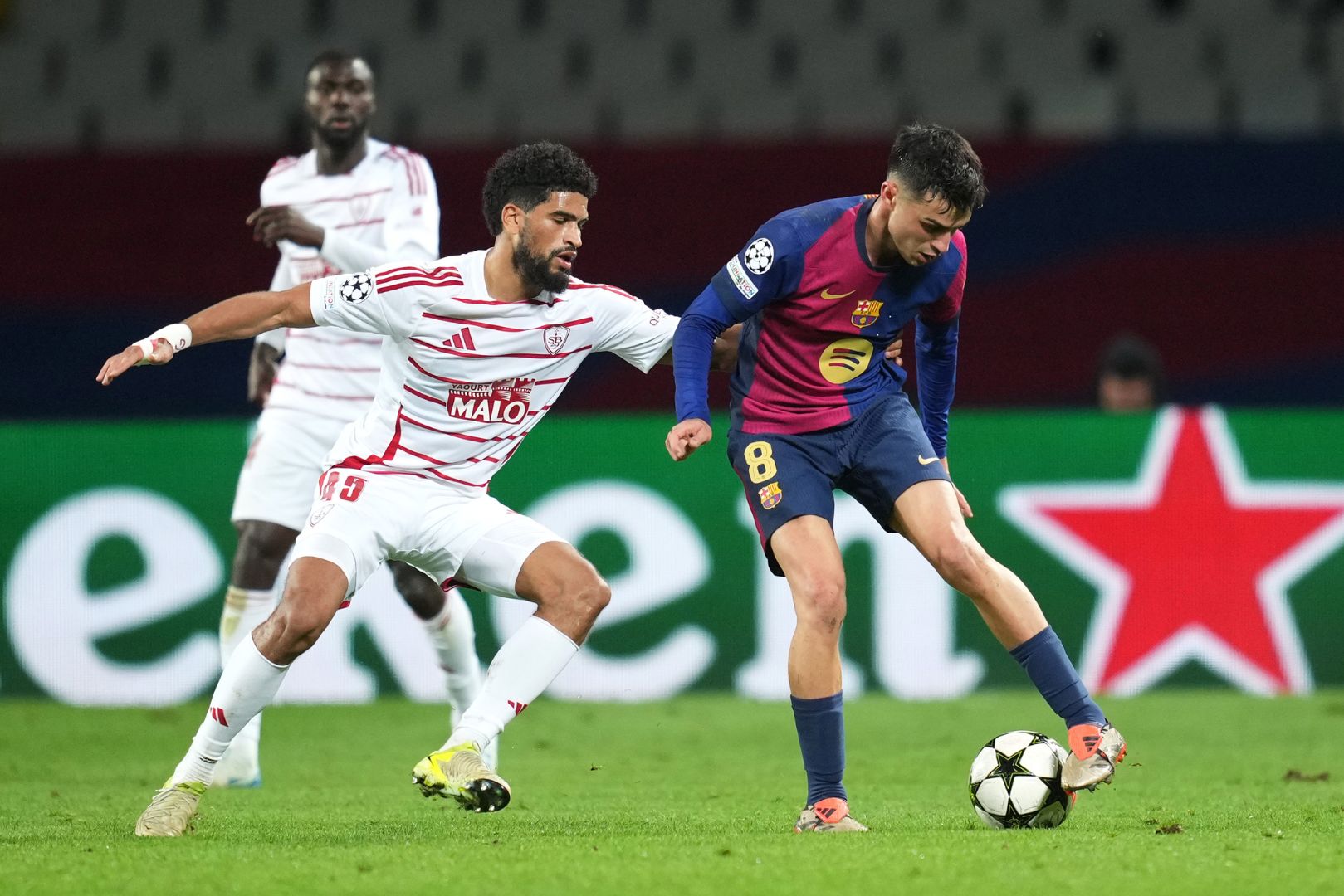 BARCELONA, SPAIN - NOVEMBER 26: Pedri of FC Barcelona controls the ball whilst under pressure from Mahdi Camara of Stade Brestois 29 during the UEFA Champions League 2024/25 League Phase MD5 match between FC Barcelona and Stade Brestois 29 at Estadi Olimpic Lluis Companys on November 26, 2024 in Barcelona, Spain.