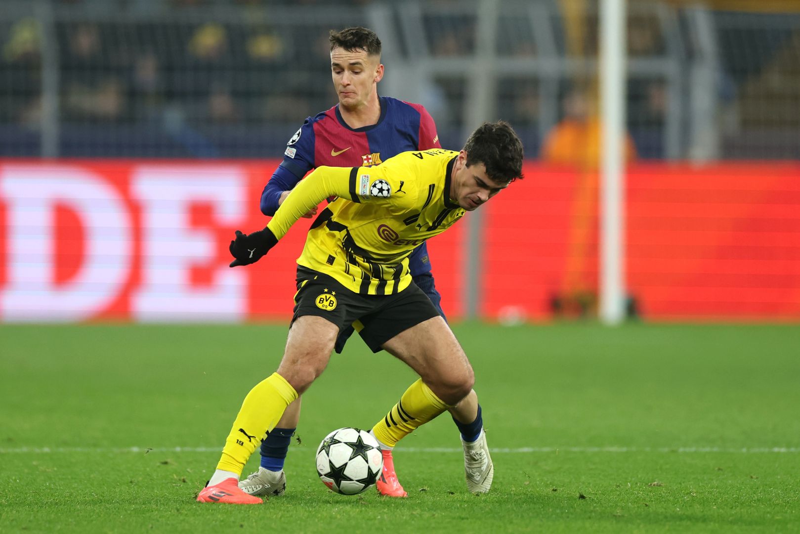 DORTMUND, GERMANY - DECEMBER 11: Giovanni Reyna of Borussia Dortmund is challenged by Marc Casado of FC Barcelona during the UEFA Champions League 2024/25 League Phase MD6 match between Borussia Dortmund and FC Barcelona at BVB Stadion Dortmund on December 11, 2024 in Dortmund, Germany.