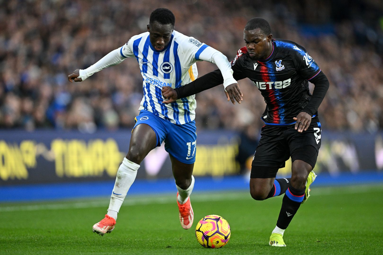 BRIGHTON, ENGLAND - DECEMBER 15: Yankuba Minteh of Brighton & Hove Albion is challenged by Tyrick Mitchell of Crystal Palace during the Premier League match between Brighton & Hove Albion FC and Crystal Palace FC at Amex Stadium on December 15, 2024 in Brighton, England.