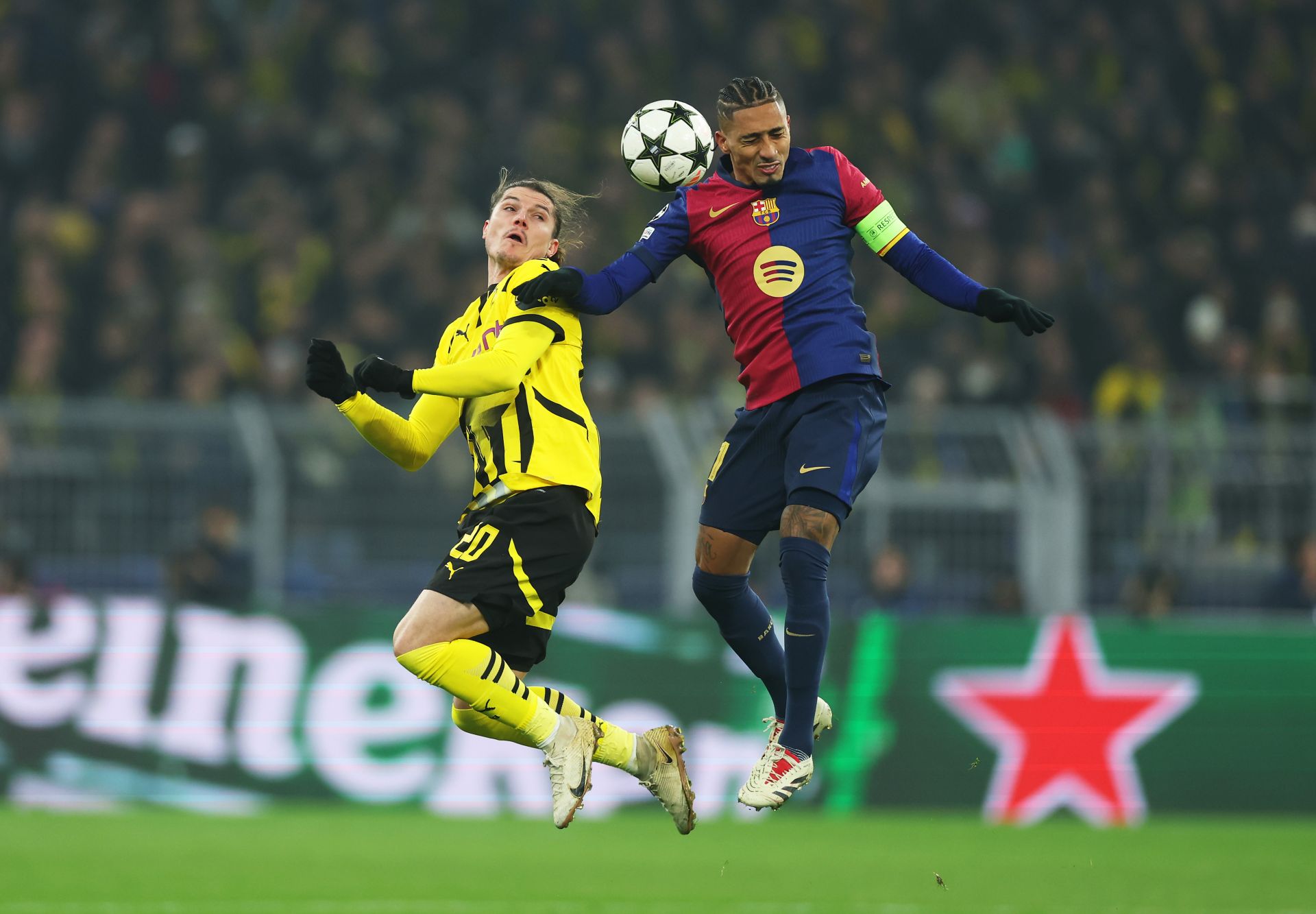 DORTMUND, GERMANY - DECEMBER 11: Raphinha of FC Barcelona contends for the aerial ball with Marcel Sabitzer of Borussia Dortmund during the UEFA Champions League 2024/25 League Phase MD6 match between Borussia Dortmund and FC Barcelona at BVB Stadion Dortmund on December 11, 2024 in Dortmund, Germany.