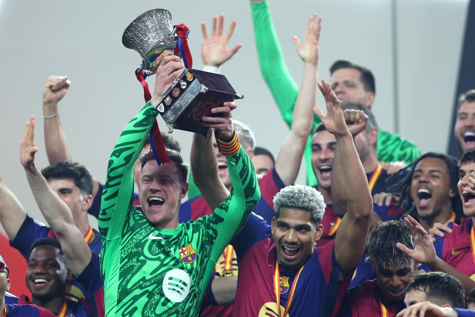 JEDDAH, SAUDI ARABIA - JANUARY 12: Inaki Pena and Ronald Araujo of FC Barcelona celebrate with the Supercopa de Espana trophy during the trophy presentation after the Spanish Super Cup Final between Real Madrid and FC Barcelona at King Abdullah Sports City on January 12, 2025 in Jeddah, Saudi Arabia.