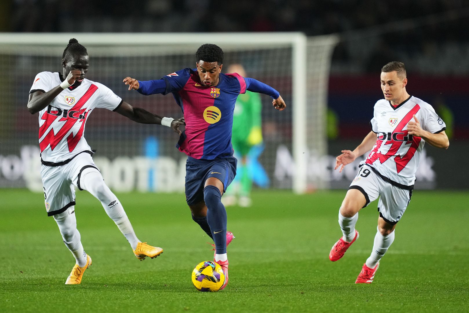 BARCELONA, SPAIN - FEBRUARY 17: Alejandro Balde of FC Barcelona is challenged by Pathe Ciss and Jorge De Frutos of Rayo Vallecano during the LaLiga match between FC Barcelona and Rayo Vallecano at Estadi Olimpic Lluis Companys on February 17, 2025 in Barcelona, Spain.