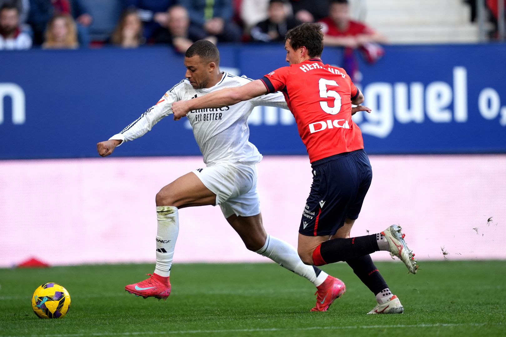 PAMPLONA, SPAIN - FEBRUARY 15: Kylian Mbappe of Real Madrid battles for possession with Jorge Herrando of CA Osasuna. during the LaLiga match between CA Osasuna and Real Madrid CF at Estadio El Sadar on February 15, 2025 in Pamplona, Spain.