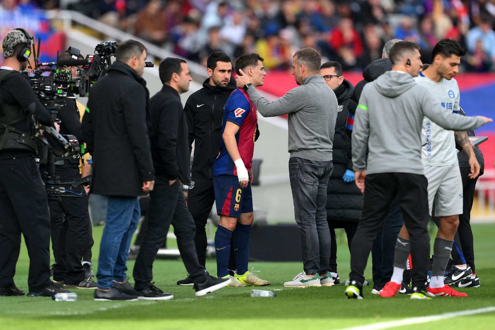 BARCELONA, SPAIN - FEBRUARY 02: Hansi Flick, Head Coach of FC Barcelona, speaks to Gavi of FC Barcelona during the LaLiga match between FC Barcelona and Deportivo Alaves at Estadi Olimpic Lluis Companys on February 02, 2025 in Barcelona, Spain.