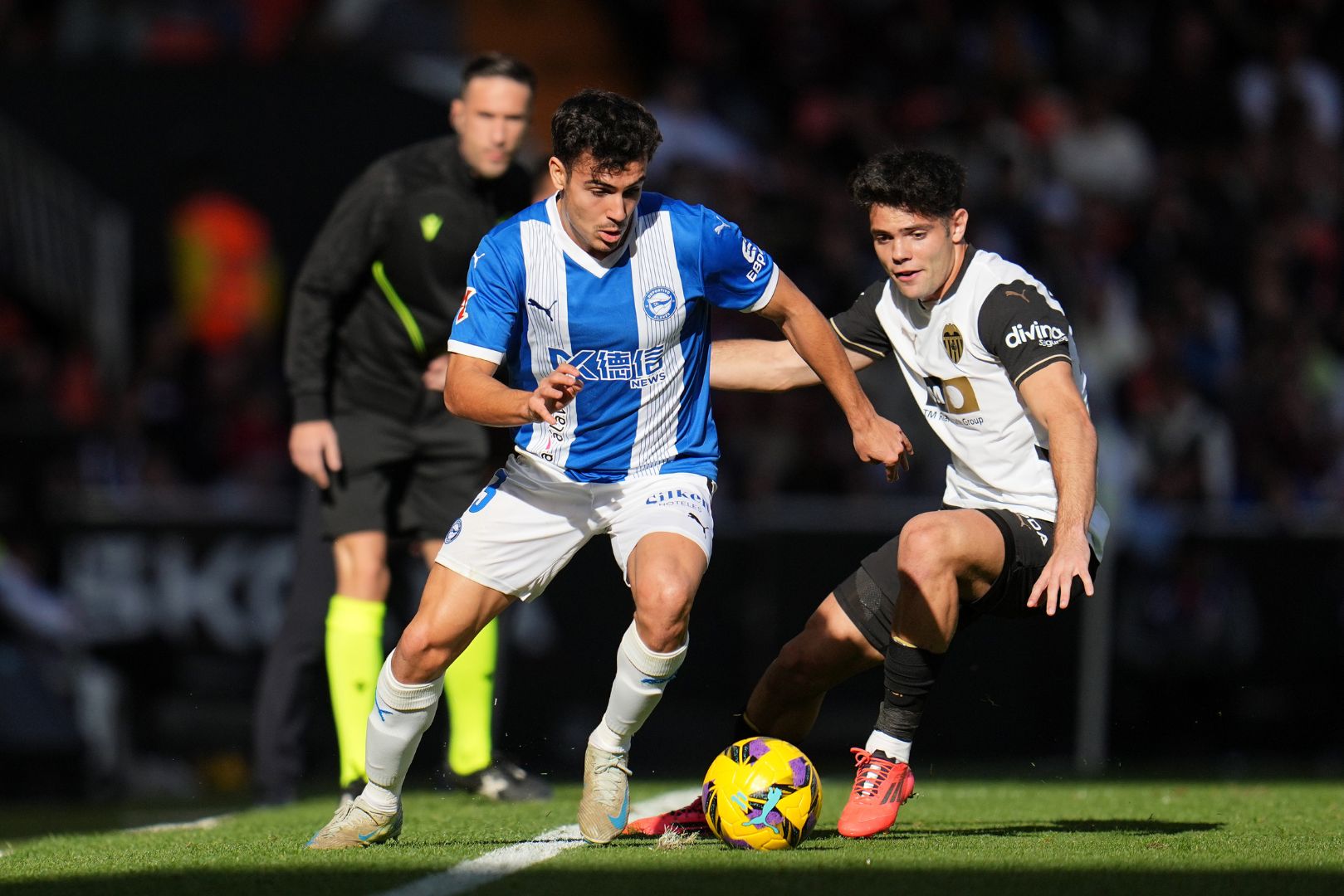 VALENCIA, SPAIN - DECEMBER 22: Manu Sanchez of Alaves runs with the ball whilst under pressure from Fran Perez of Valencia CF during the LaLiga match between Valencia CF and Deportivo Alaves at Estadio Mestalla on December 22, 2024 in Valencia, Spain.