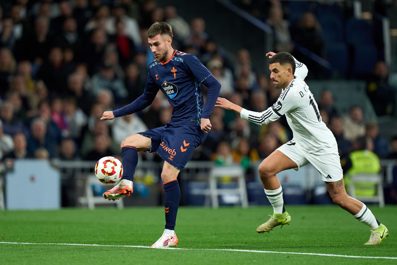 MADRID, SPAIN - JANUARY 16: Oscar Mingueza of Celta Vigo is challenged by Dani Ceballos of Real Madrid during the Copa Del Rey match between Real Madrid and Celta de Vigo at Estadio Santiago Bernabeu on January 16, 2025 in Madrid, Spain.
