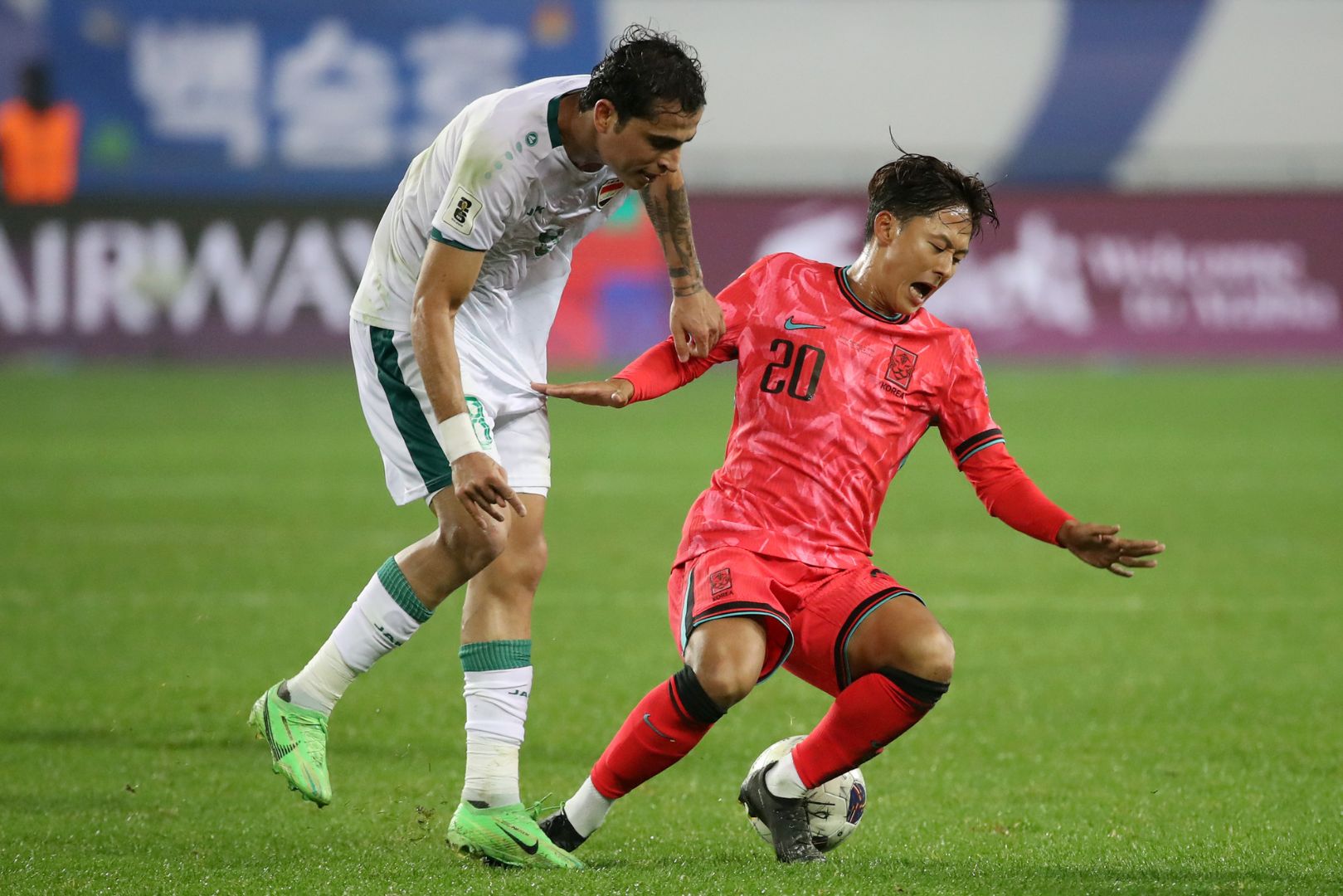 YONGIN, SOUTH KOREA - OCTOBER 15: Lee Seungwoo of South Korea (R) is tackled by Ibrahim Bayesh of Iraq (L) during the FIFA World Cup Asian Third Qualifier Group B match between South Korea and Iraq at Mireu Stadium on October 15, 2024 in Yongin, South Korea.
