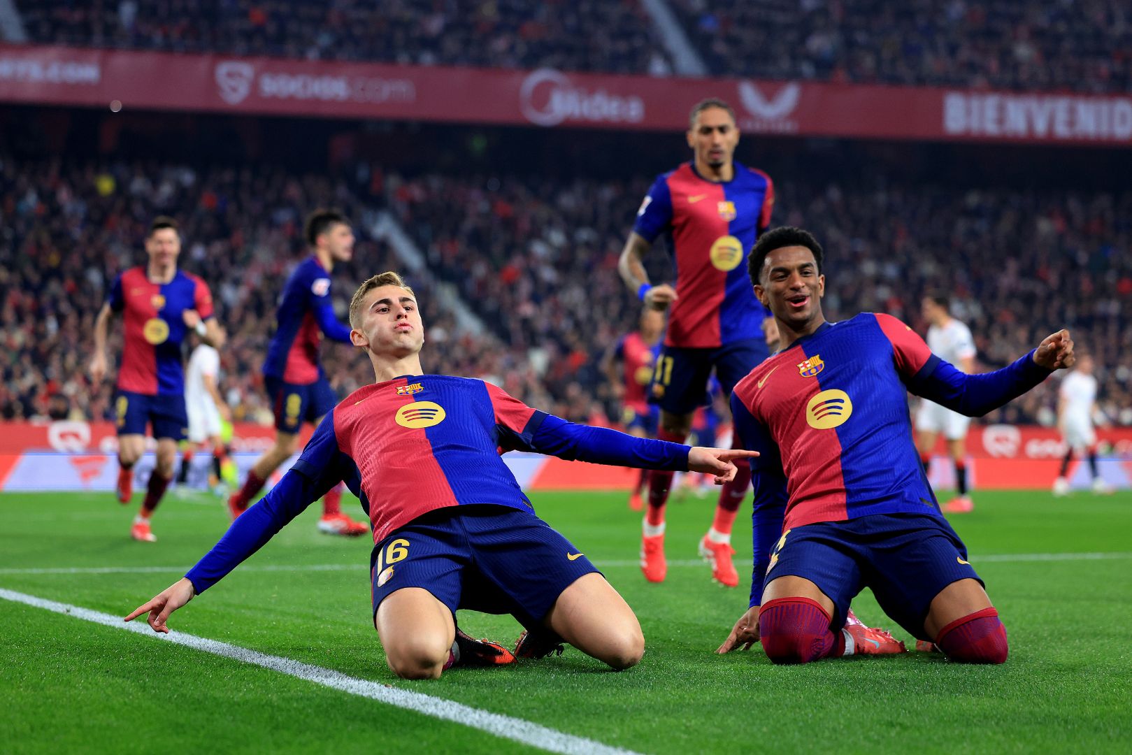 SEVILLE, SPAIN - FEBRUARY 09: Fermin Lopez of FC Barcelona celebrates scoring his team's second goal with teammate Alejandro Balde during the LaLiga match between Sevilla FC and FC Barcelona at Estadio Ramon Sanchez Pizjuan on February 09, 2025 in Seville, Spain.