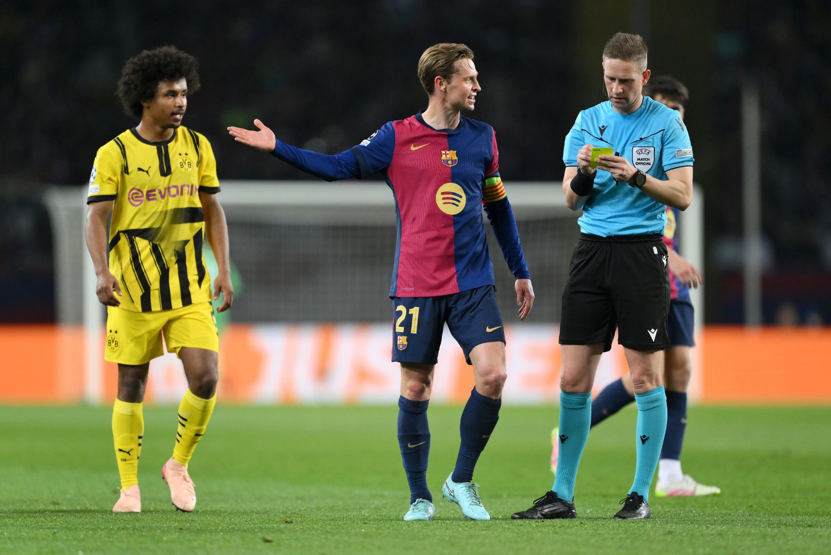 BARCELONA, SPAIN - APRIL 09: Frenkie de Jong of FC Barcelona speaks to Match Referee Espen Eskas after he shows a yellow card to Karim Adeyemi of Borussia Dortmund during the UEFA Champions League 2024/25 Quarter Final First Leg match between FC Barcelona and Borussia Dortmund at Estadi Olimpic Lluis Companys on April 09, 2025 in Barcelona, Spain.