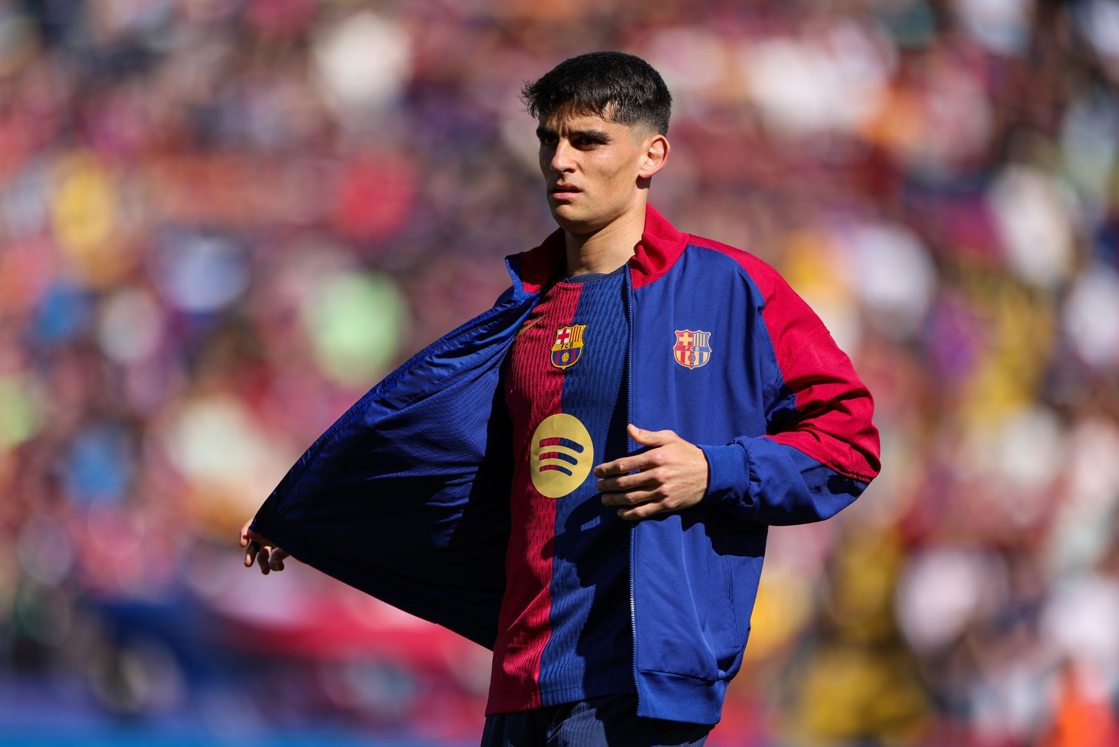 BARCELONA, SPAIN - MARCH 30: Gerard Martin of FC Barcelona takes his jacket off during the LaLiga match between FC Barcelona and Girona FC at Estadi Olimpic Lluis Companys on March 30, 2025 in Barcelona, Spain.
