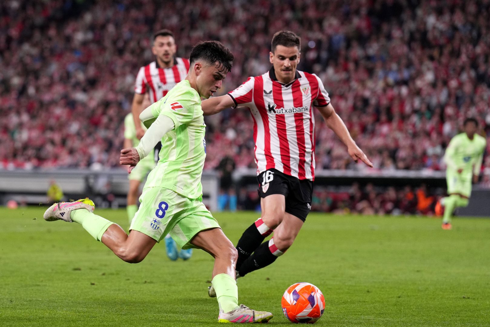 BILBAO, SPAIN - MAY 25: Pedri of FC Barcelona crosses the ball whilst under pressure from Inigo Ruiz de Galarreta of Athletic Club during the LaLiga match between Athletic Club and FC Barcelona at Estadio de San Mames on May 25, 2025 in Bilbao, Spain.