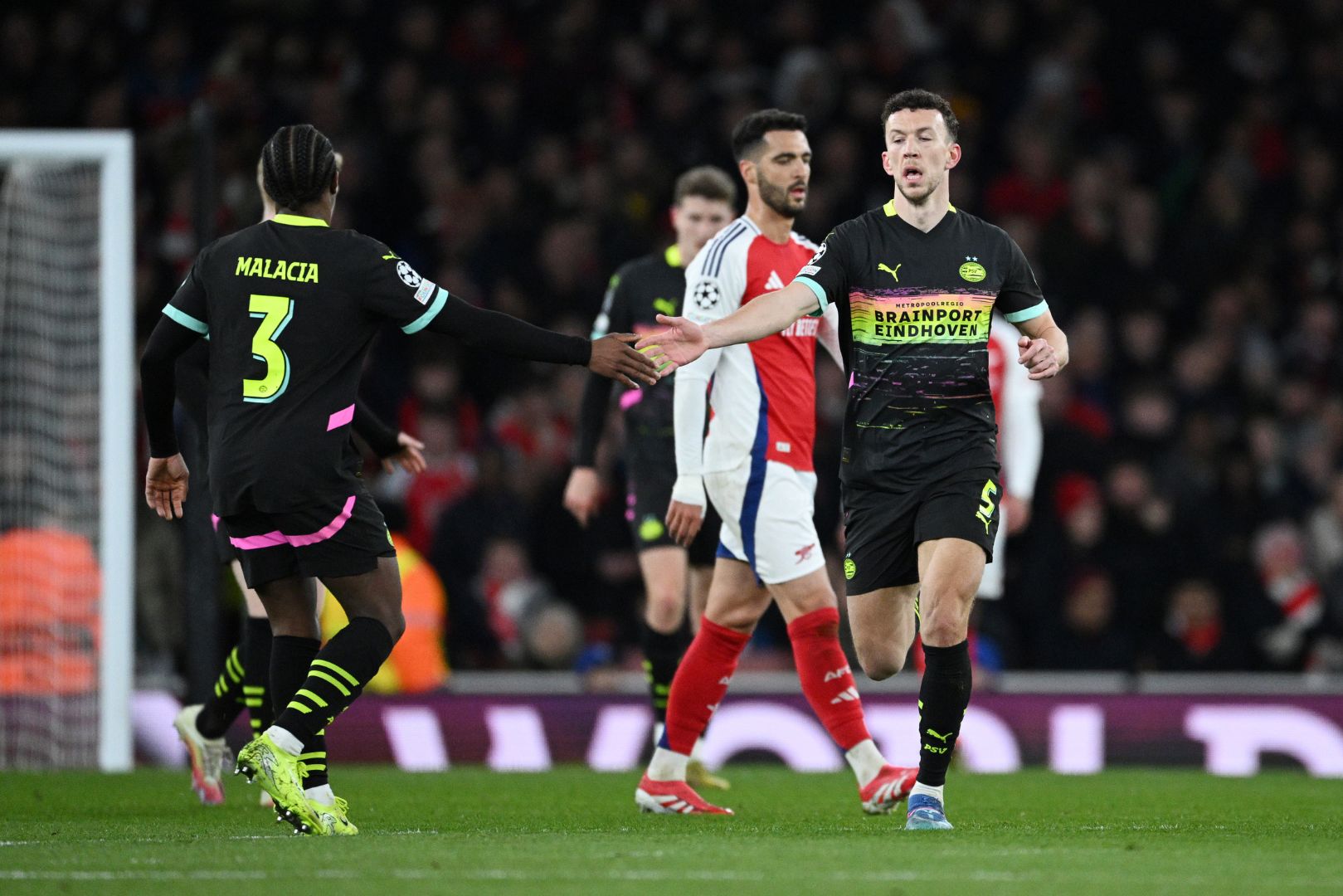 LONDON, ENGLAND - MARCH 12: Ivan Perisic of PSV Eindhoven celebrates scoring his team's first goal with teammate Tyrell Malacia during the UEFA Champions League 2024/25 Round of 16 Second Leg match between Arsenal FC and PSV at Arsenal Stadium on March 12, 2025 in London, England.