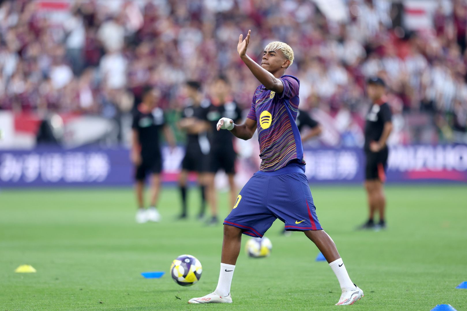 KOBE, JAPAN - JULY 27: FC Barcelona's Lamine Yamal waves to the crowd as he takes part in the warms up before the preseason friendly between Vissel Kobe and FC Barcelona at Noevir Stadium Kobe on July 27, 2025 in Kobe, Hyogo, Japan.