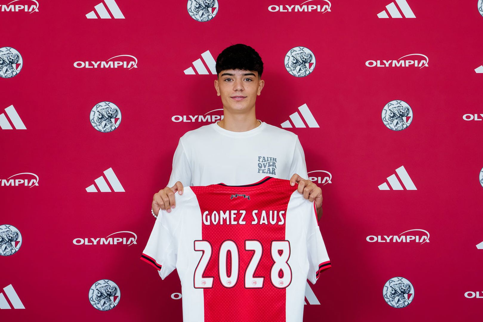 Eloi Gómez poses with an Ajax jersey after signing.
