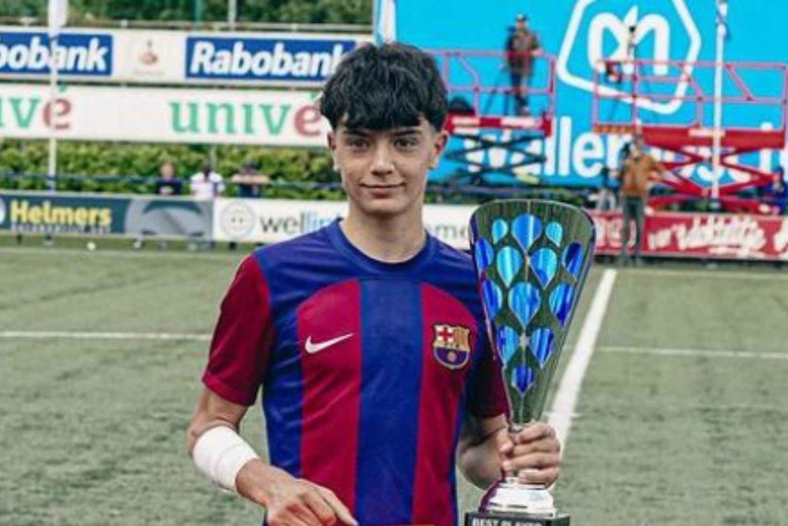 Eloi Gómez in a Barcelona jersey holding a youth tournament trophy.
