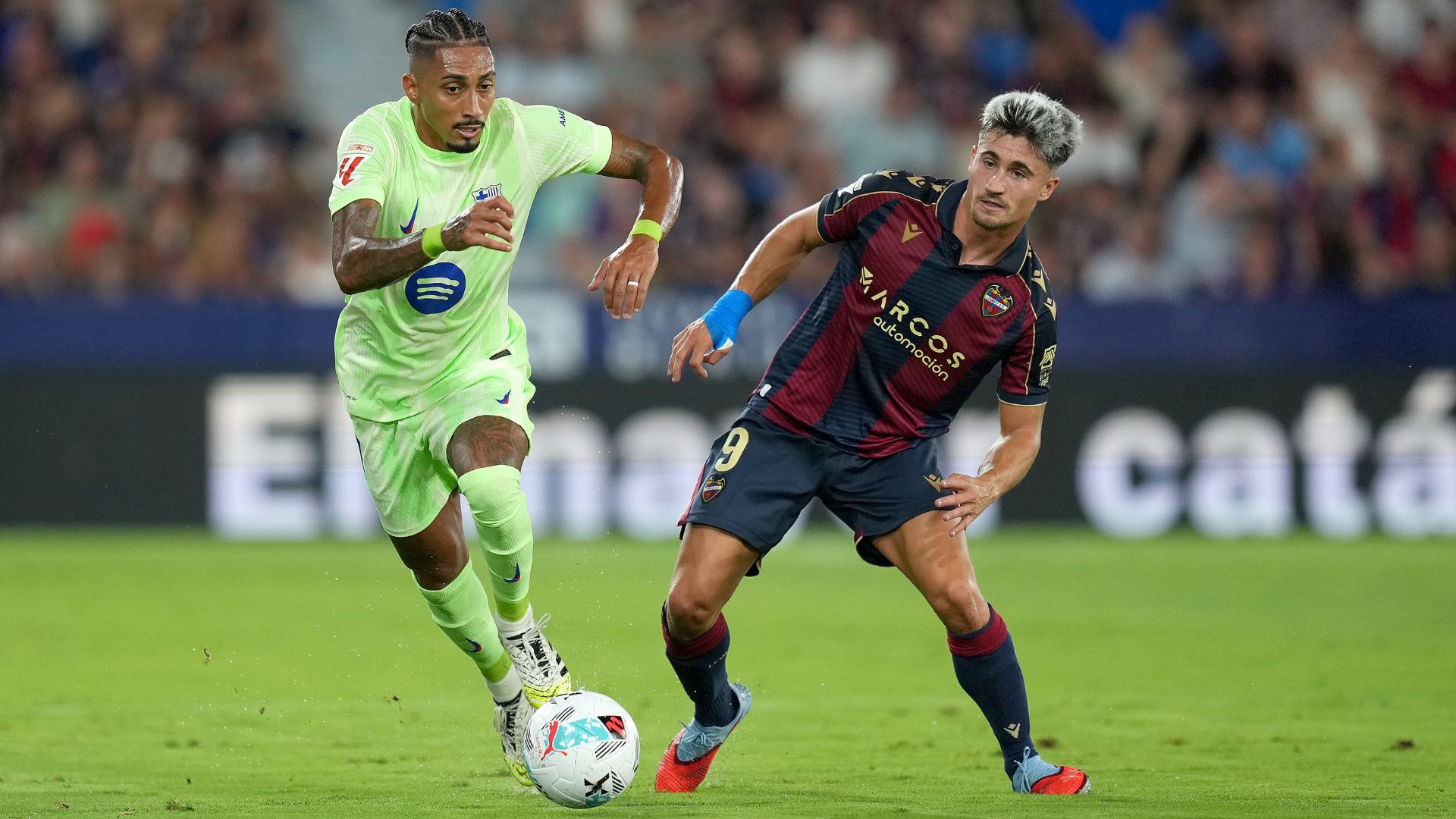 VALENCIA, SPAIN - AUGUST 23: Raphinha of FC Barcelona runs with the ball whilst under pressure from Ivan Romero of Levante UD during the LaLiga EA Sports match between Levante UD and FC Barcelona at Ciutat de Valencia on August 23, 2025 in Valencia, Spain.