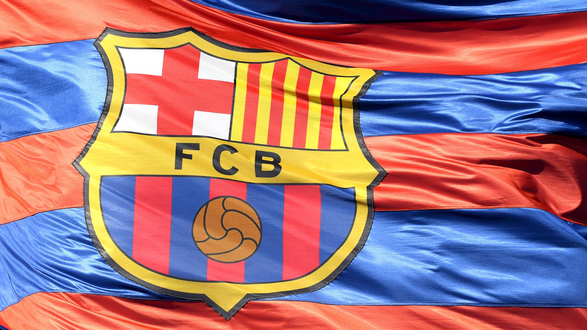 BARCELONA, SPAIN - APRIL 04: The Barcelona logo is seen on a flag waving above the stadium prior to the UEFA Champions League Quarter Final Leg One match between FC Barcelona and AS Roma at Camp Nou on April 4, 2018 in Barcelona, Spain.