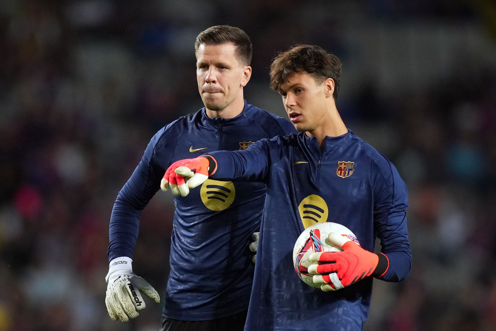 BARCELONA, SPAIN - OCTOBER 20: Wojciech Szczesny and Diego Kochen interact during the warm up prior to the La Liga EA Sports match between FC Barcelona and Sevilla FC at Estadi Olimpic Lluis Companys on October 20, 2024 in Barcelona, Spain.