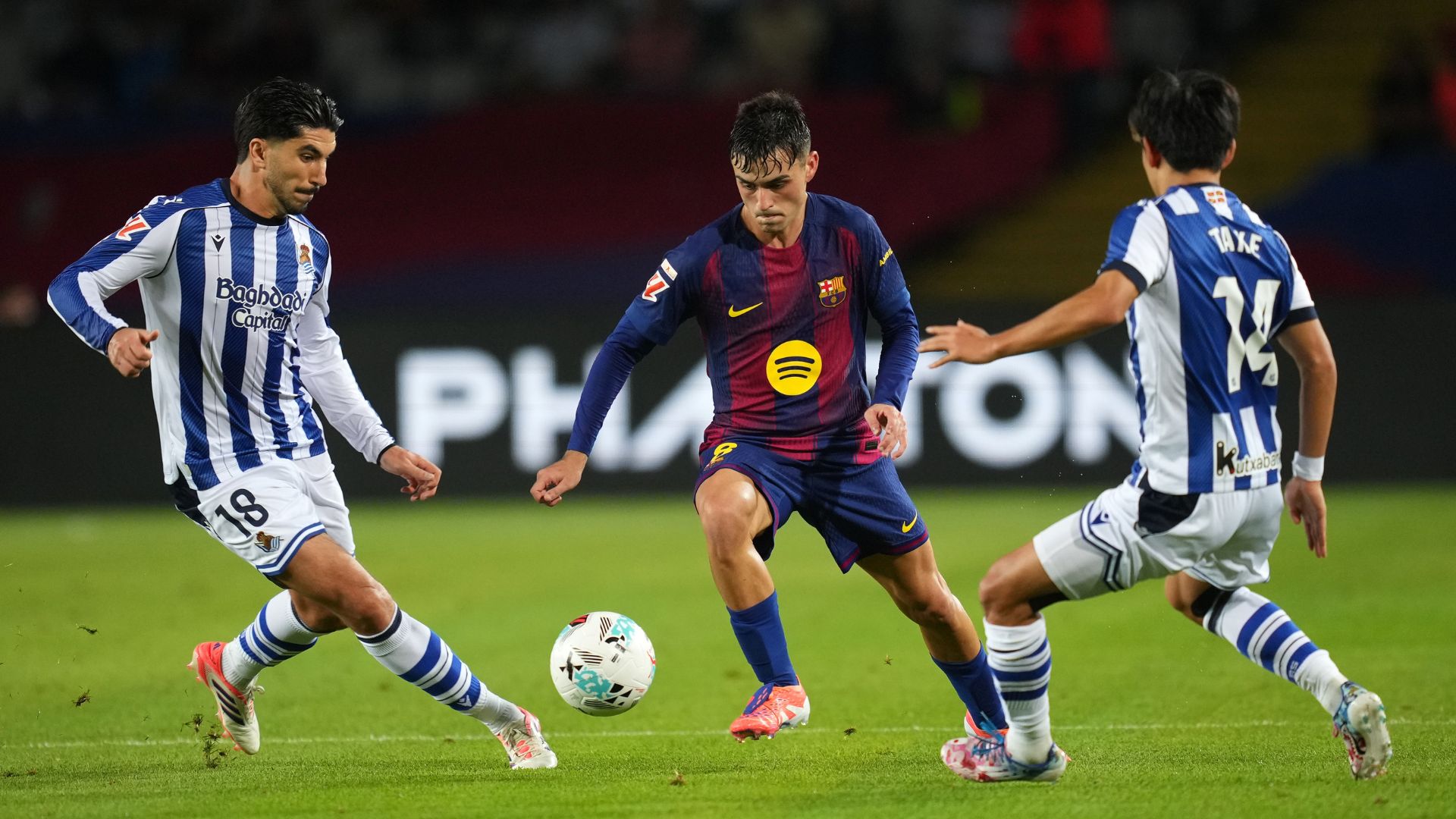 BARCELONA, SPAIN - SEPTEMBER 28: Pedri of FC Barcelona takes on Carlos Soler and Takefusa Kubo of Real Sociedad during the LaLiga EA Sports match between FC Barcelona and Real Sociedad at Estadi Olimpic Lluis Companys on September 28, 2025 in Barcelona, Spain.