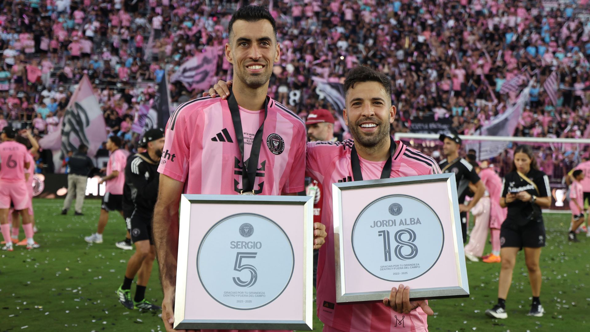 FORT LAUDERDALE, FLORIDA - DECEMBER 06: Sergio Busquets #5 and Jordi Alba #18 of Inter Miami CF pose with a plaque after their retirement announcement following the championship win in the Audi 2025 MLS Cup Final match between Inter Miami CF and Vancouver Whitecaps FC at Chase Stadium on December 06, 2025 in Fort Lauderdale, Florida.