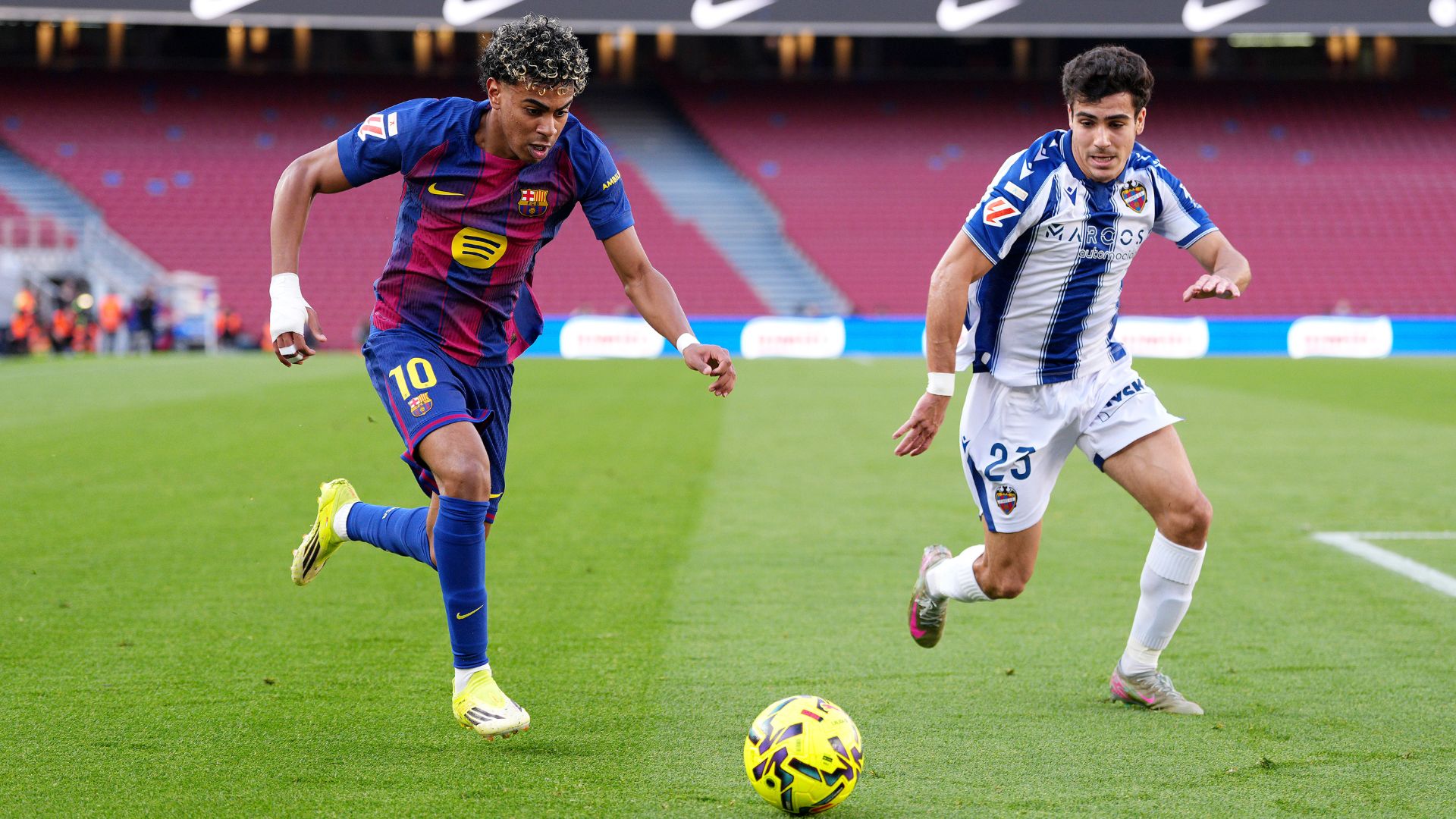 BARCELONA, SPAIN - FEBRUARY 22: Lamine Yamal of FC Barcelona runs with the ball whilst under pressure from Manu Sanchez of Levante UD during the LaLiga EA Sports match between FC Barcelona and Levante UD at Spotify Camp Nou on February 22, 2026 in Barcelona, Spain.